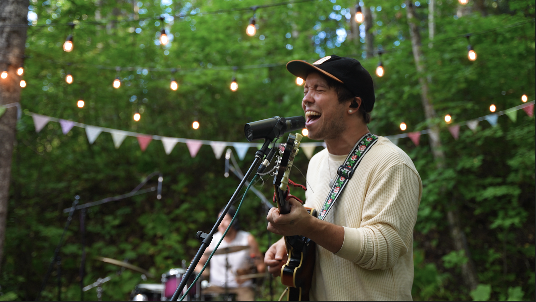 Elijah Quinn playing guitar during a live outdoor performance