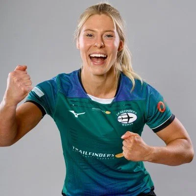 A woman in a sports jersey celebrating with a fist pump.
