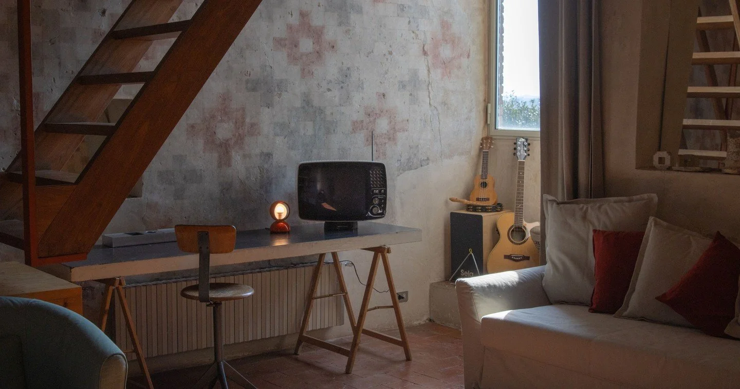 A quiet refuge where creativity lives.⁠
⁠
In the Library Room at Torre di Sopra, time slows and inspiration finds its rhythm. Between the pages of well-loved books, the notes of a melody, and the soft glow of the Eclisse lamp.⁠
⁠
A cozy couch, a writ