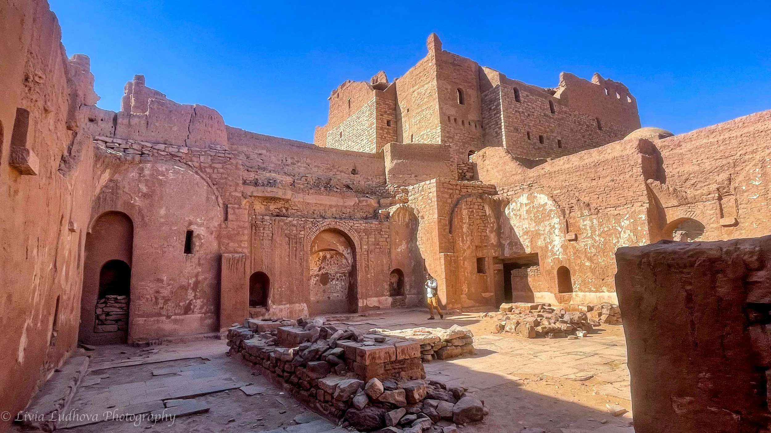 Inside the Monastery of St. Simeon, where arched doorways and thick mudbrick walls once sheltered a remote Coptic community above the Nile.