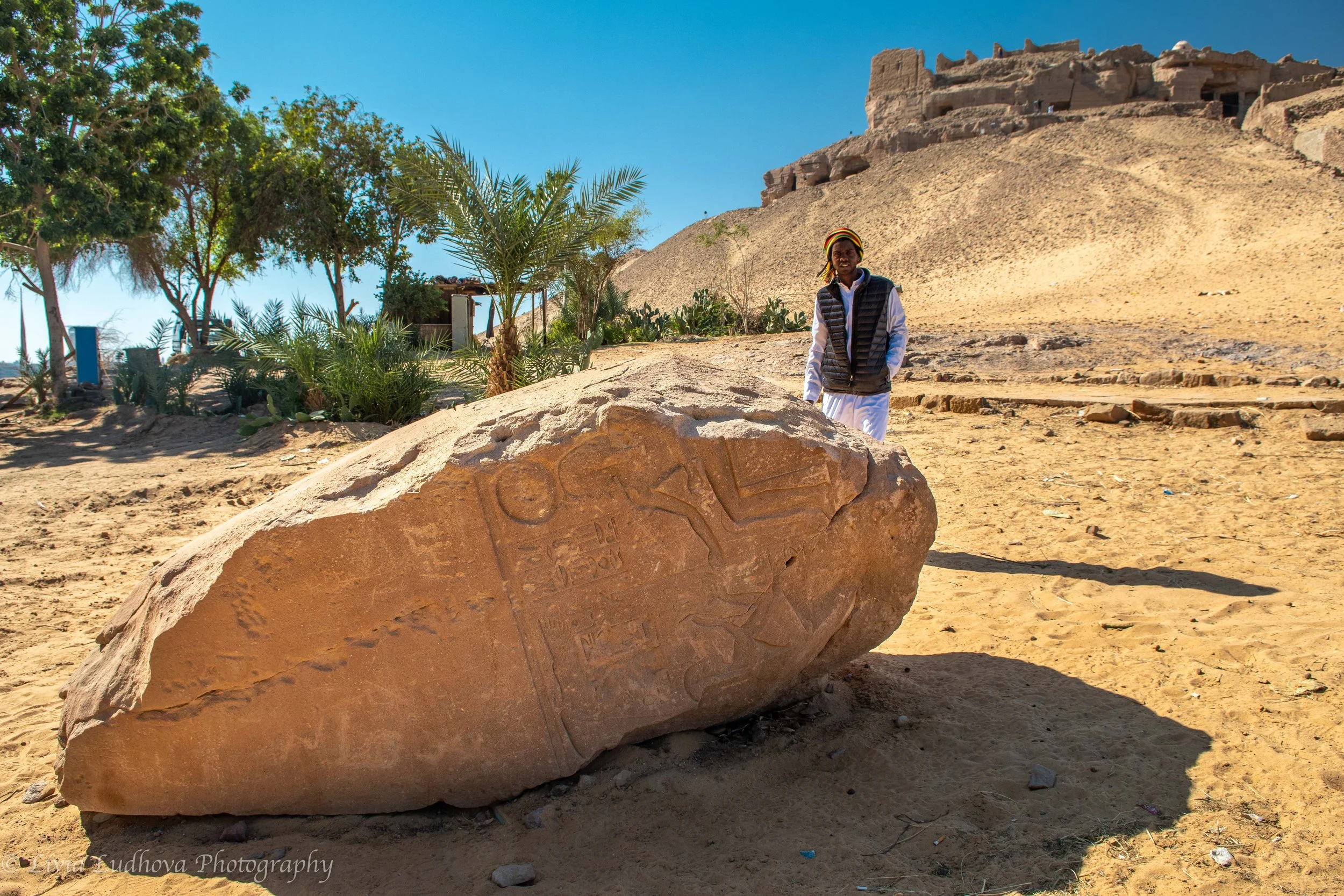 a fallen sandstone block carved with ancient reliefs lies along the approach to the Tombs of the Nobles,