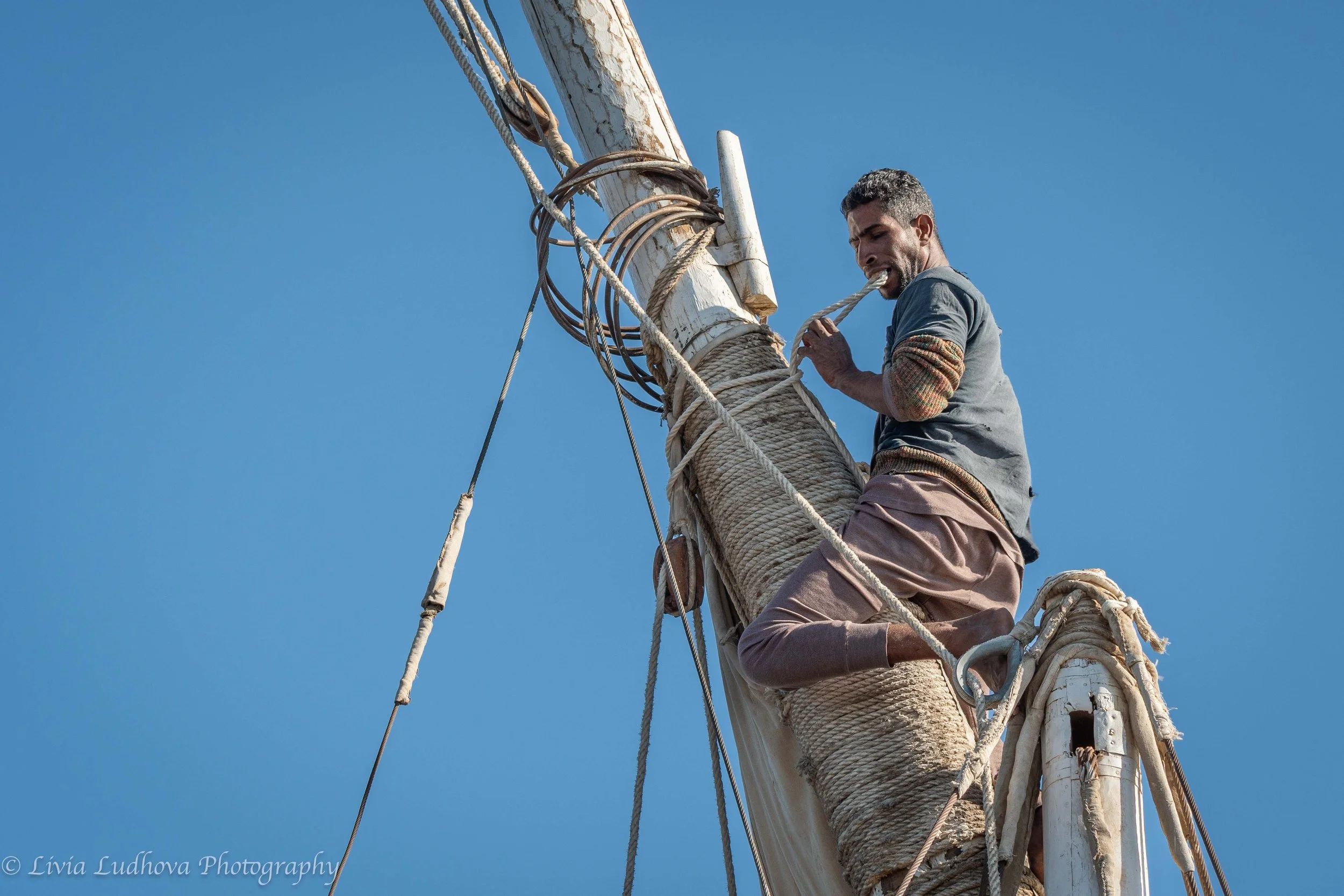 Handling sails while climbed on the mast.