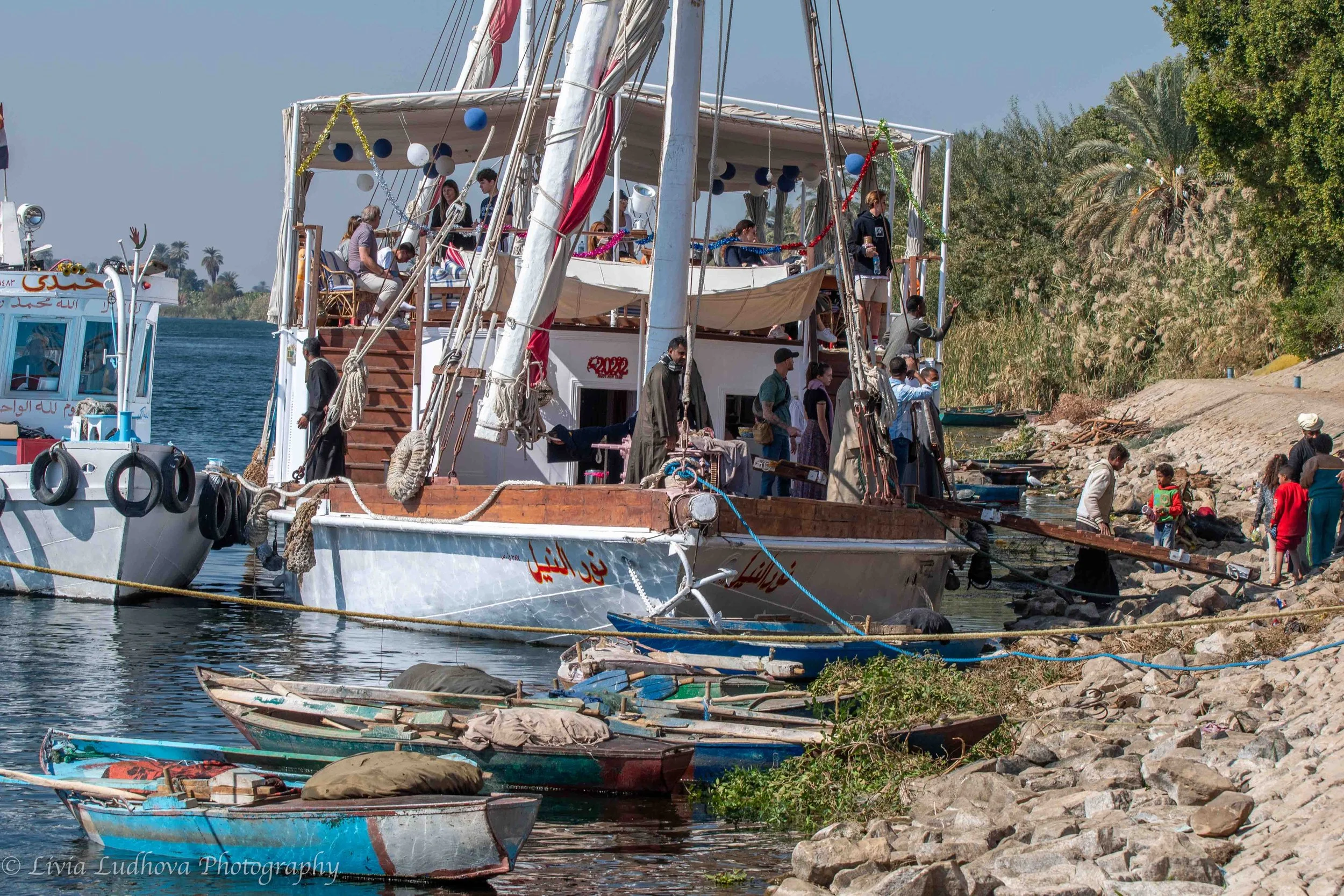 Riverbank activity and moored boats.