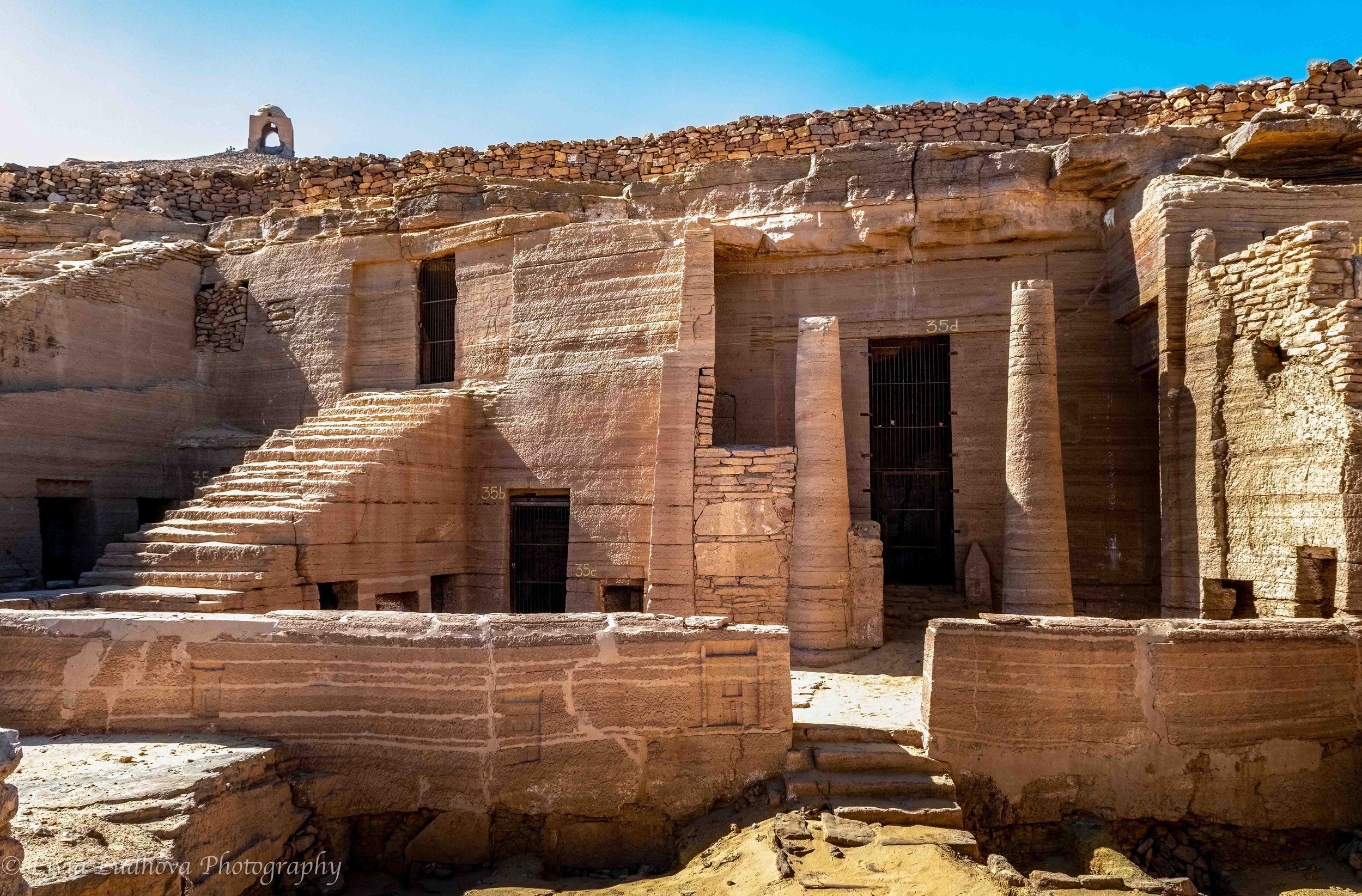 Rock-cut tomb façade carved directly into Nubian sandstone, with columned entrance and stepped approach reflecting elite non-royal burial architecture of the New Kingdom.