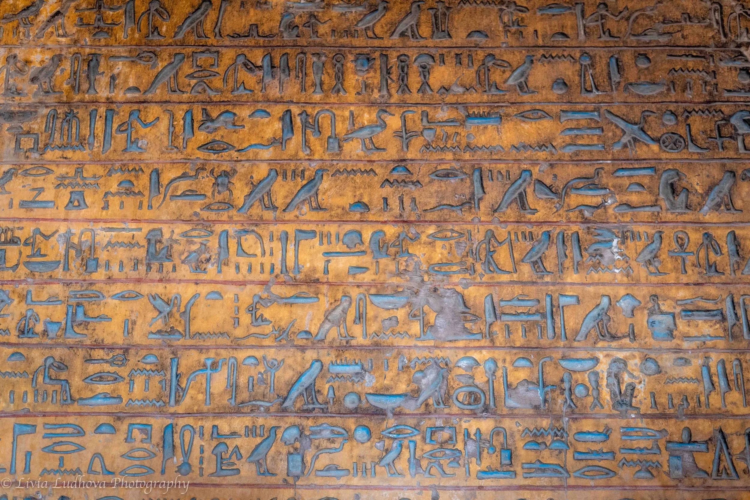 Hieroglyphic inscription with preserved pigments, El Kab — vivid blue and yellow traces illustrate the original polychrome surface of tomb texts.