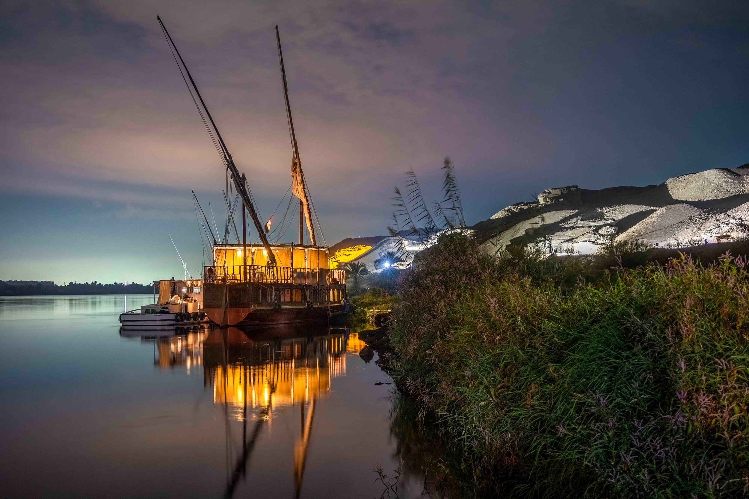 Dahabiya illuminated at night — vessel as temporary home.