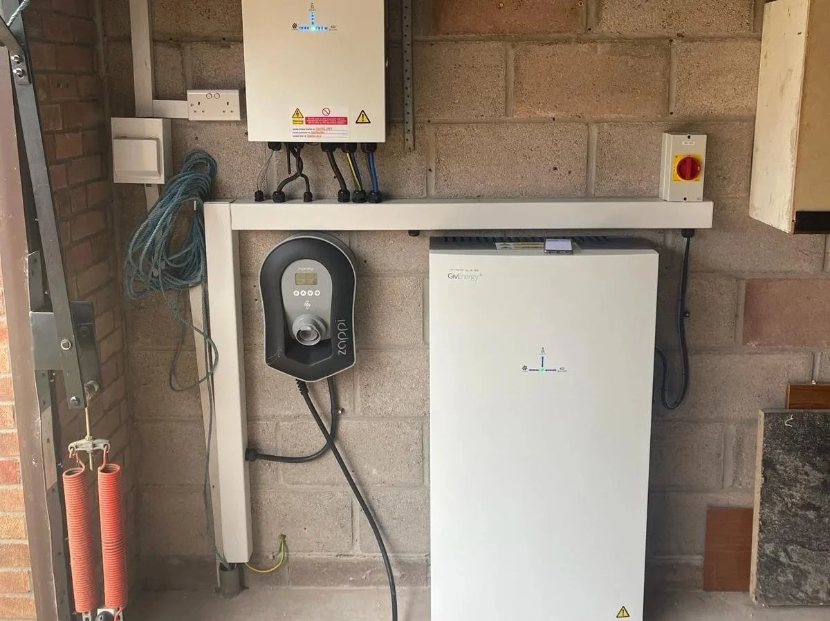 Battery storage for a home setup with electrical control box, and wiring mounted on a brick wall.