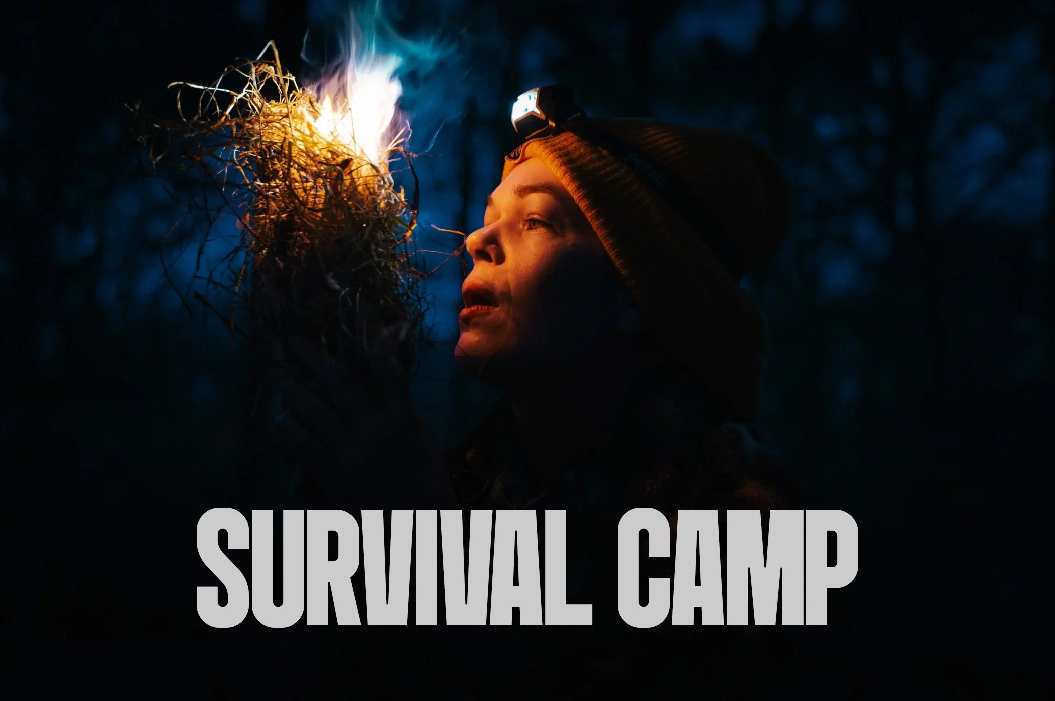 Frau im Dunkeln bei Nacht mit Stirnlampe, hält ein kleines Feuermittel aus Ästen.