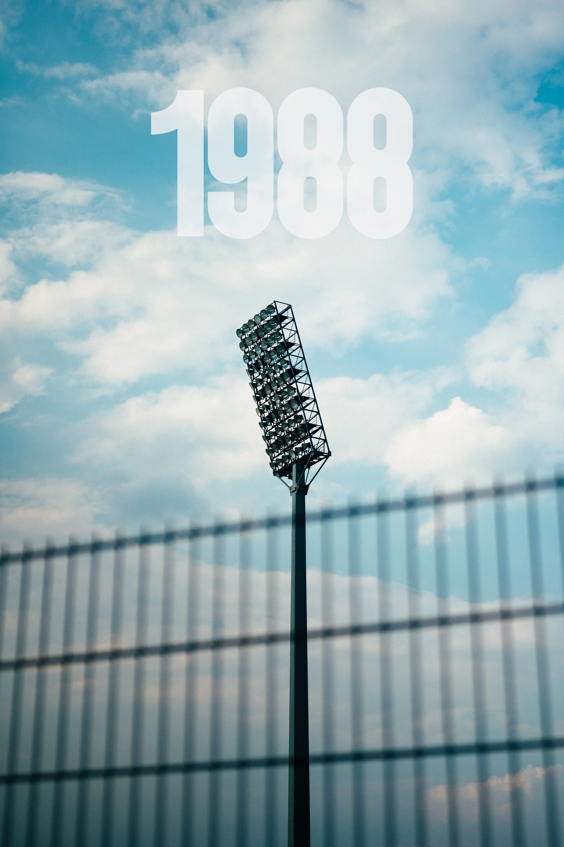 Sportfeld mit Flutlichtmast gegen den Himmel mit Wolken, die Zahl 1988 im Himmel