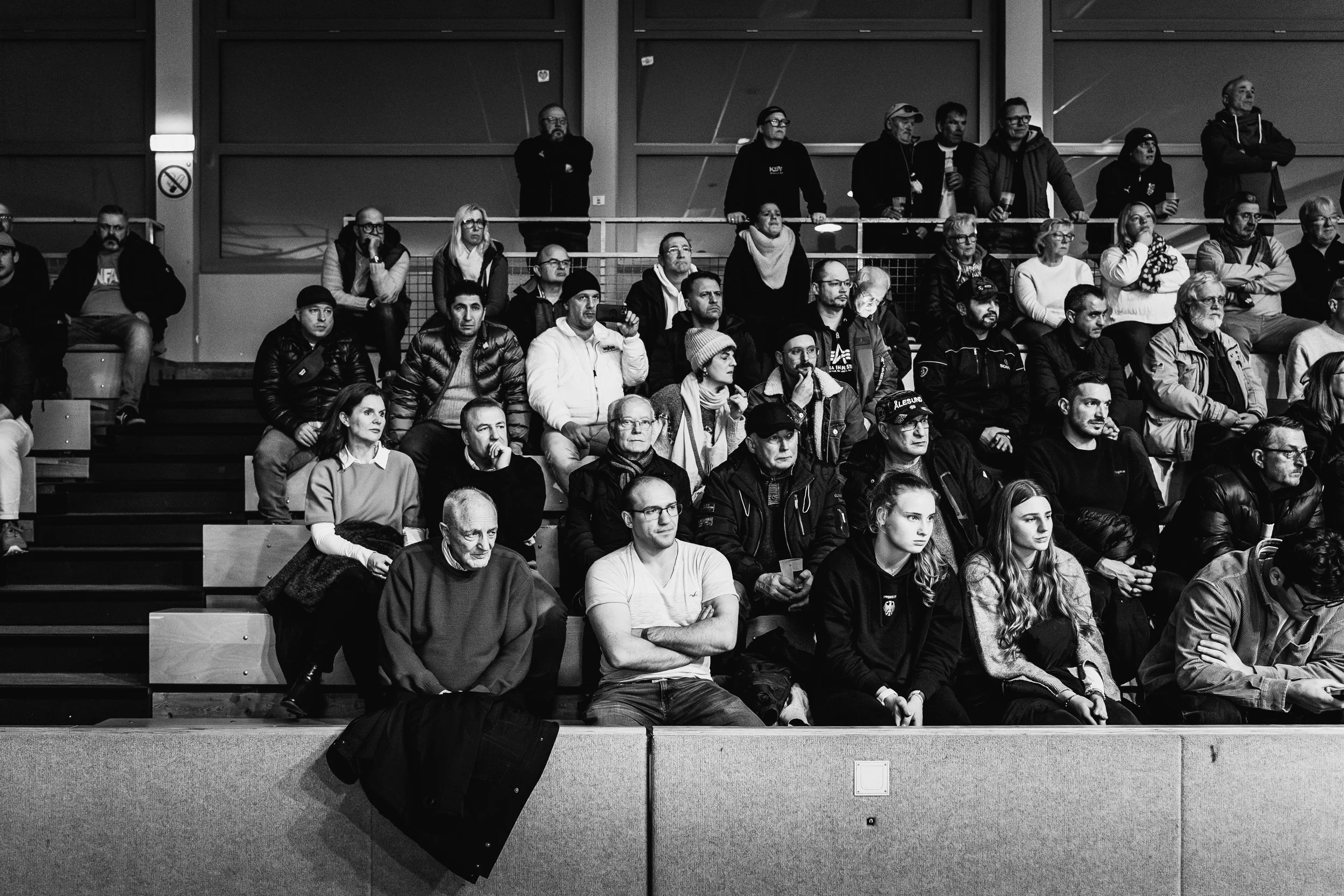 Menschen sitzen und stehen in einem Stadion, während eines Events.