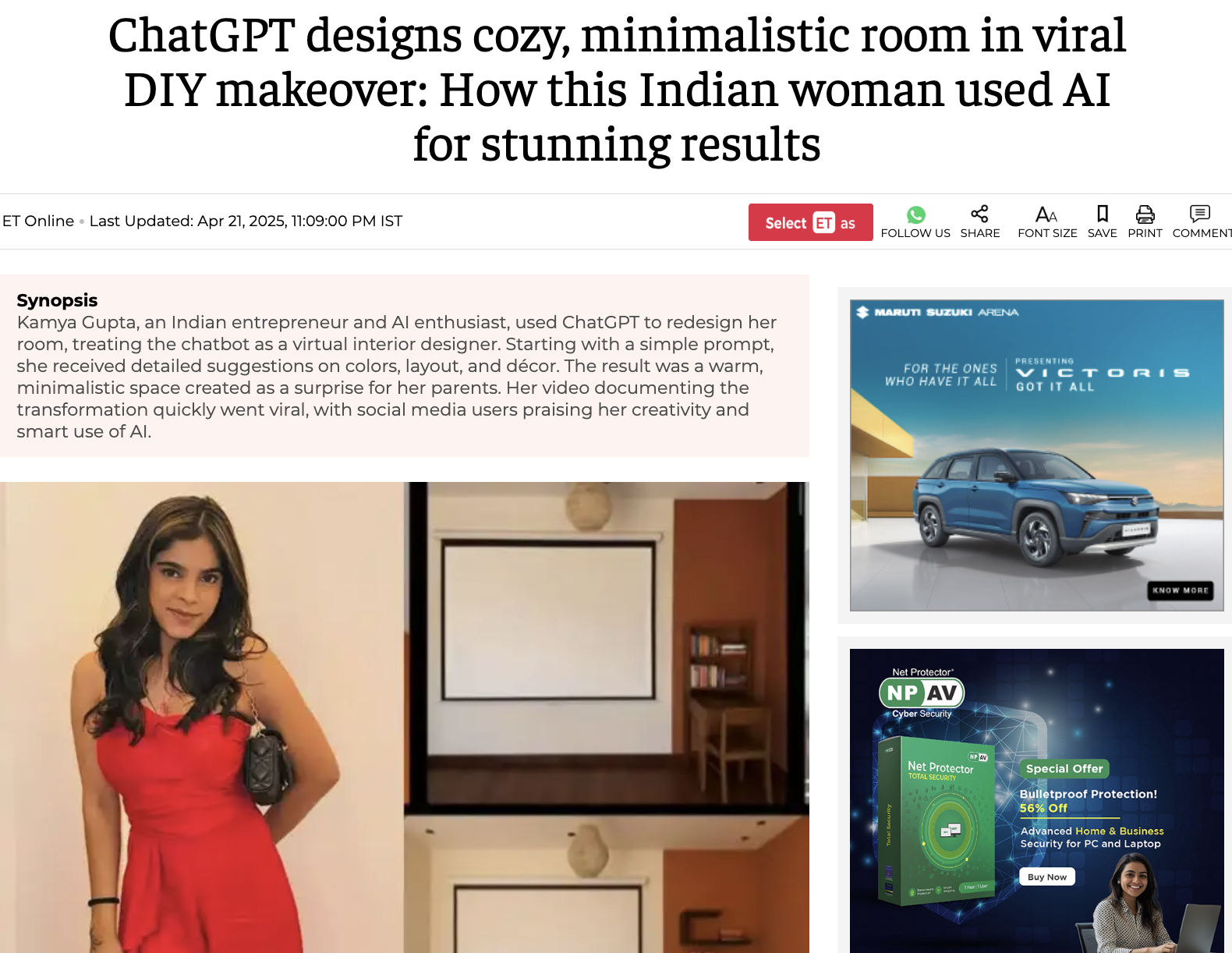 The image shows a woman in a red dress with long dark hair, holding a camera attached to a strap over her shoulder, standing in a cozy, minimalist room with light-colored walls and framed pictures, a small shelf, and a lamp. The room has a warm, inviting atmosphere with modern decor.