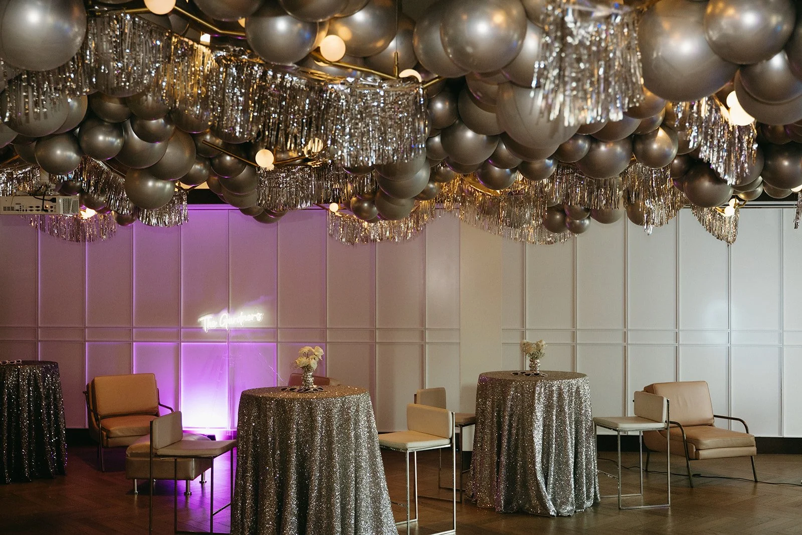 Disco cowgirl wedding reception at The Glencoe Club in Calgary, featuring silver balloons, shimmering tinsel ceiling installations, and sequin cocktail tables.