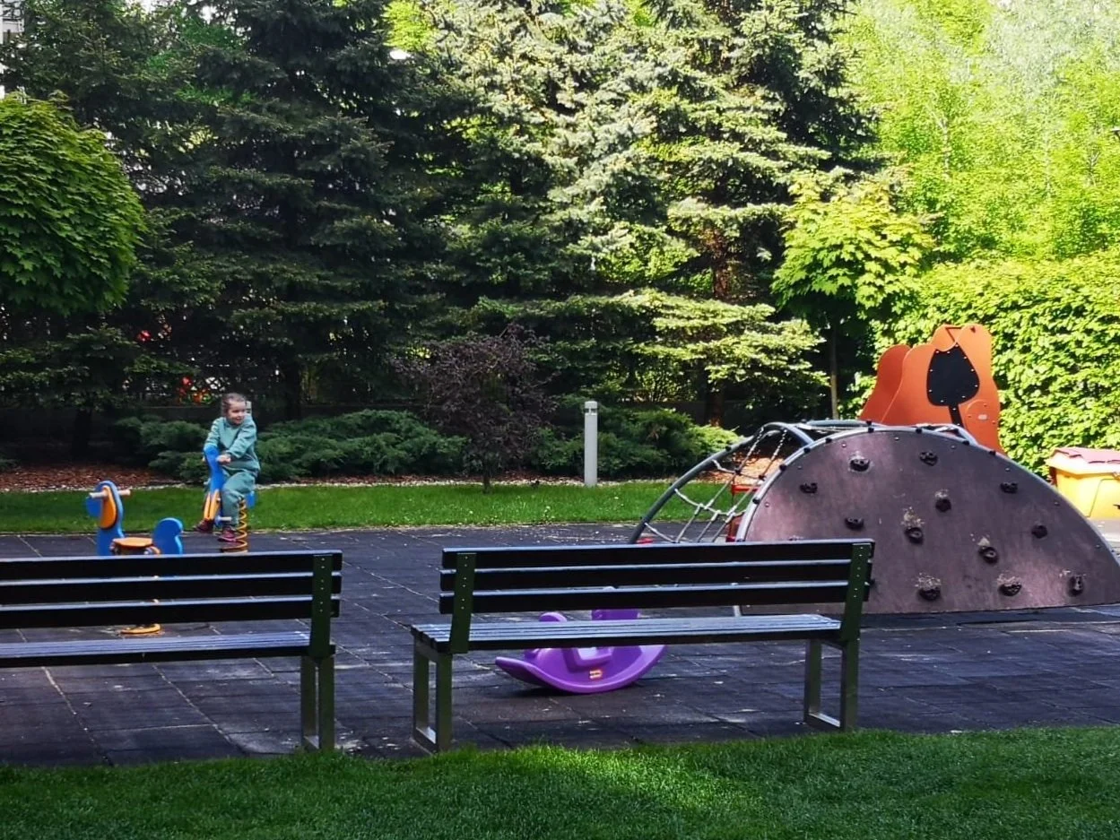 After long travels through the border, daughter Kristina enjoys the park near their airbnb in Warsaw.