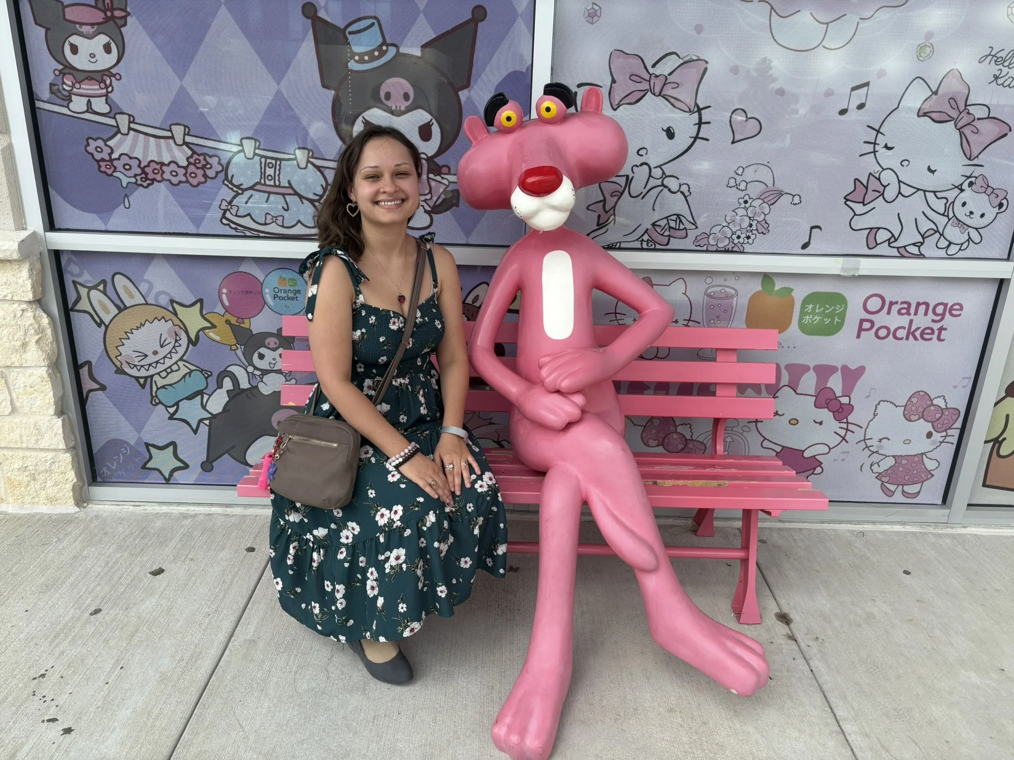 A woman smiling on a bench beside a cartoon statue, reflecting on childhood memories and emotional healing
