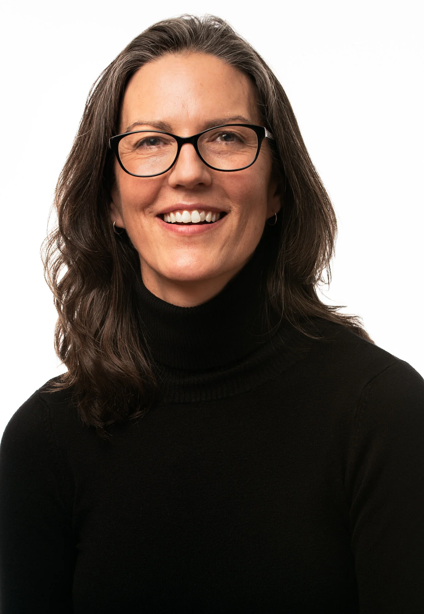 headshot portrait against a white background of a dark haired woman with glasses and wearing a black sweater