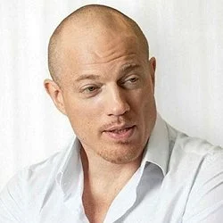 En man med vit skjorta som tittar åt sidan.