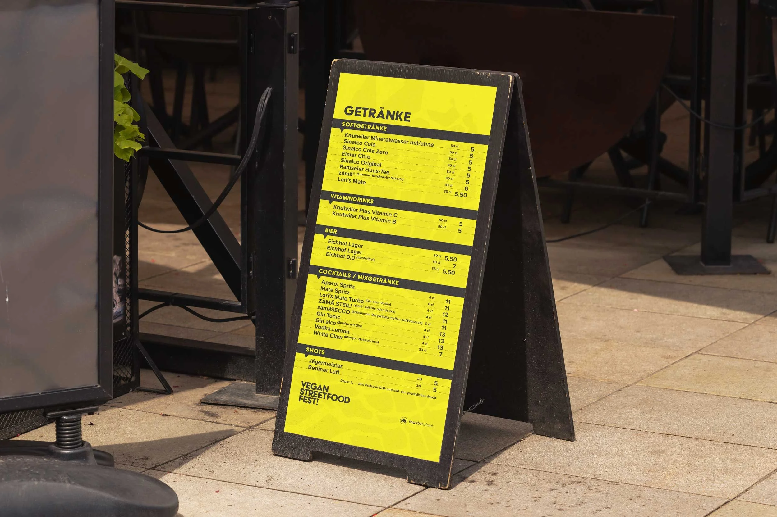 Getränkekarte des Vegan Streetfood Fest auf gelbem Aufsteller am Festivalgelände