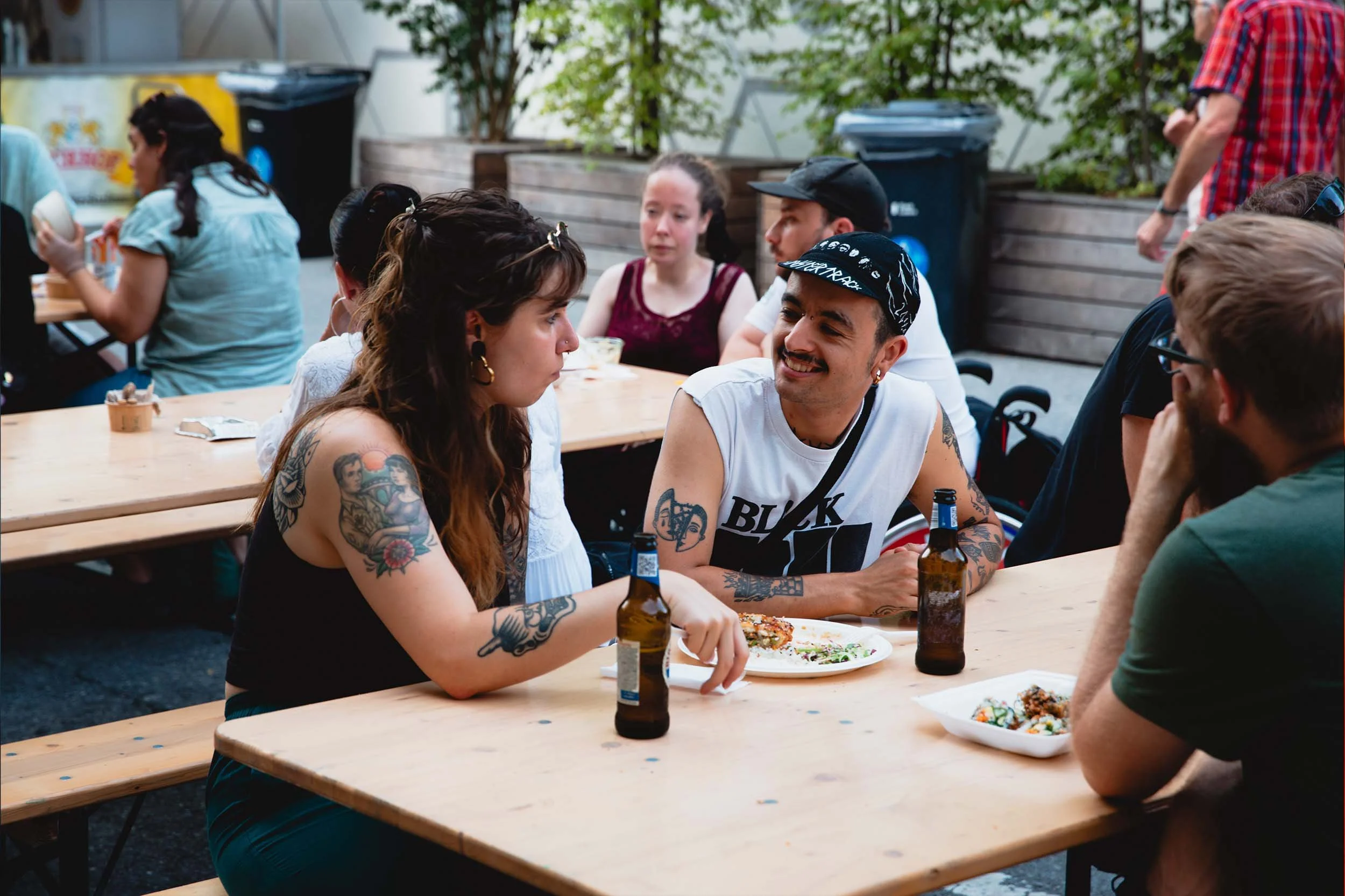 Gäste an Festbänken mit veganem Streetfood und Getränken am Festival in Luzern