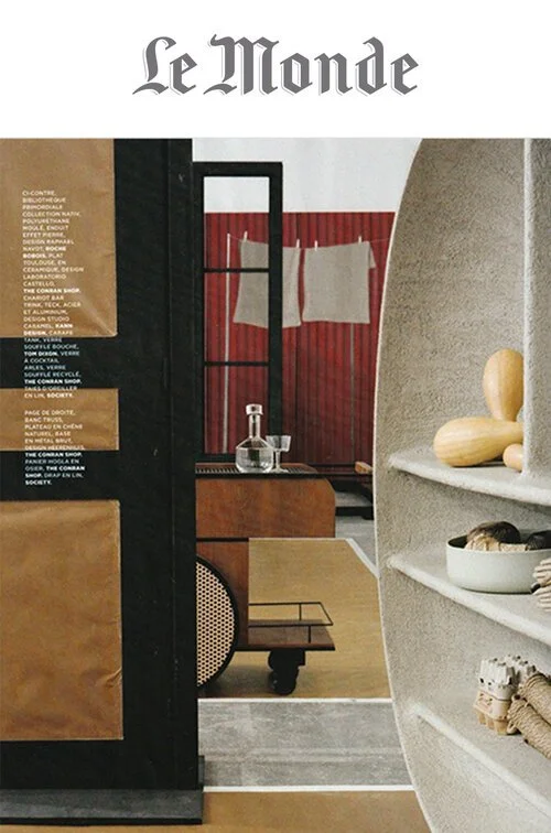 Cover of Le Monde magazine featuring a modern interior design scene with shelves, a framed window, and decorative objects.