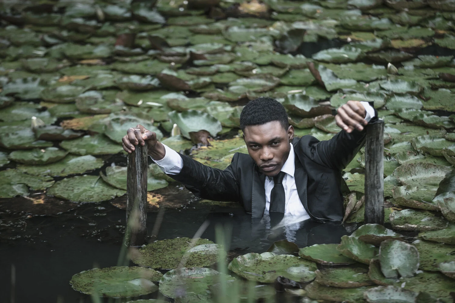 fashion-editorial-men-in-black-water-lily-pond-garden-12.jpg