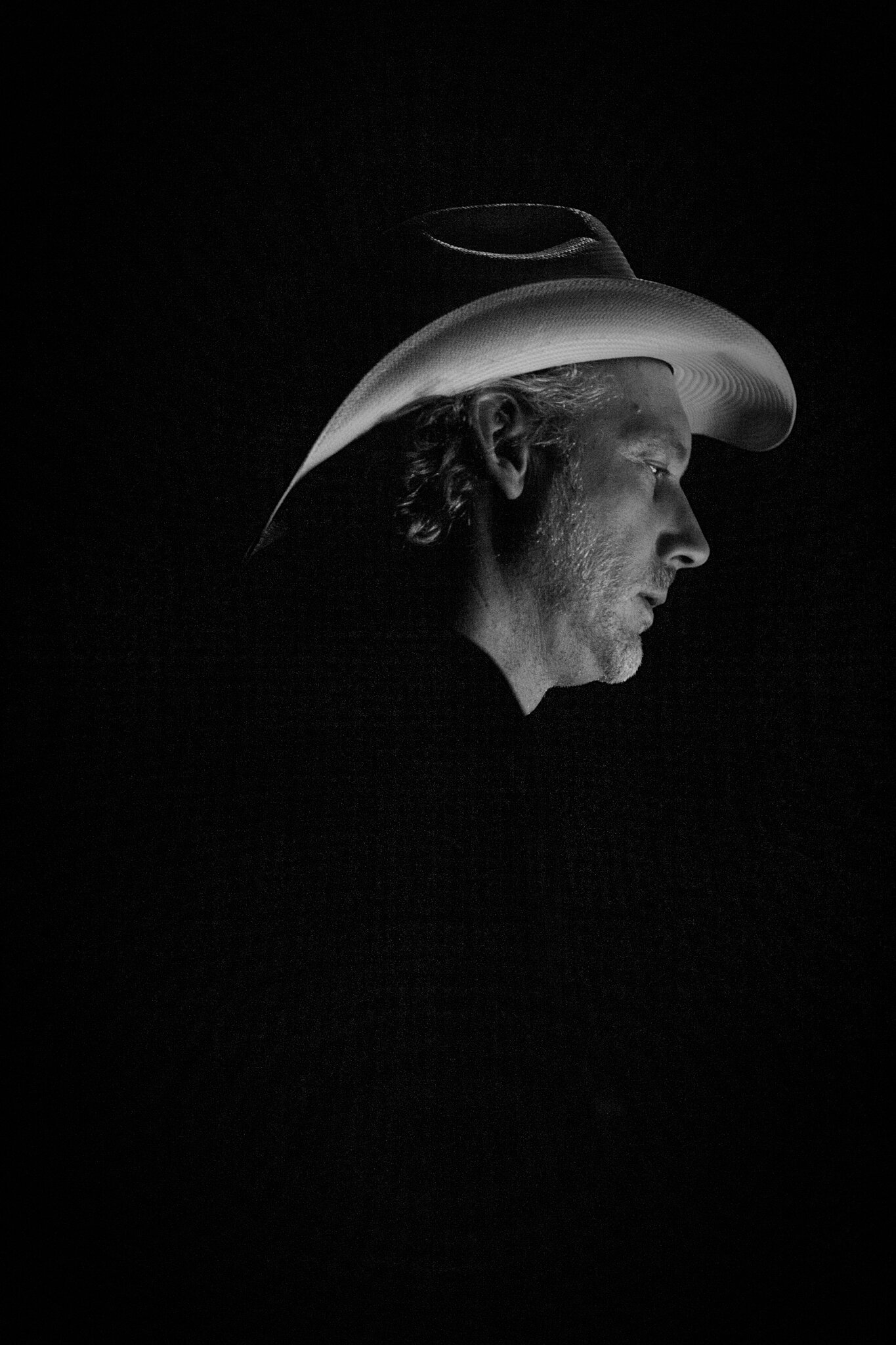 Schwarz-Weiß-Foto von Richard Dorfmeister in Profilansicht, der einen Cowboy-Hut trägt.