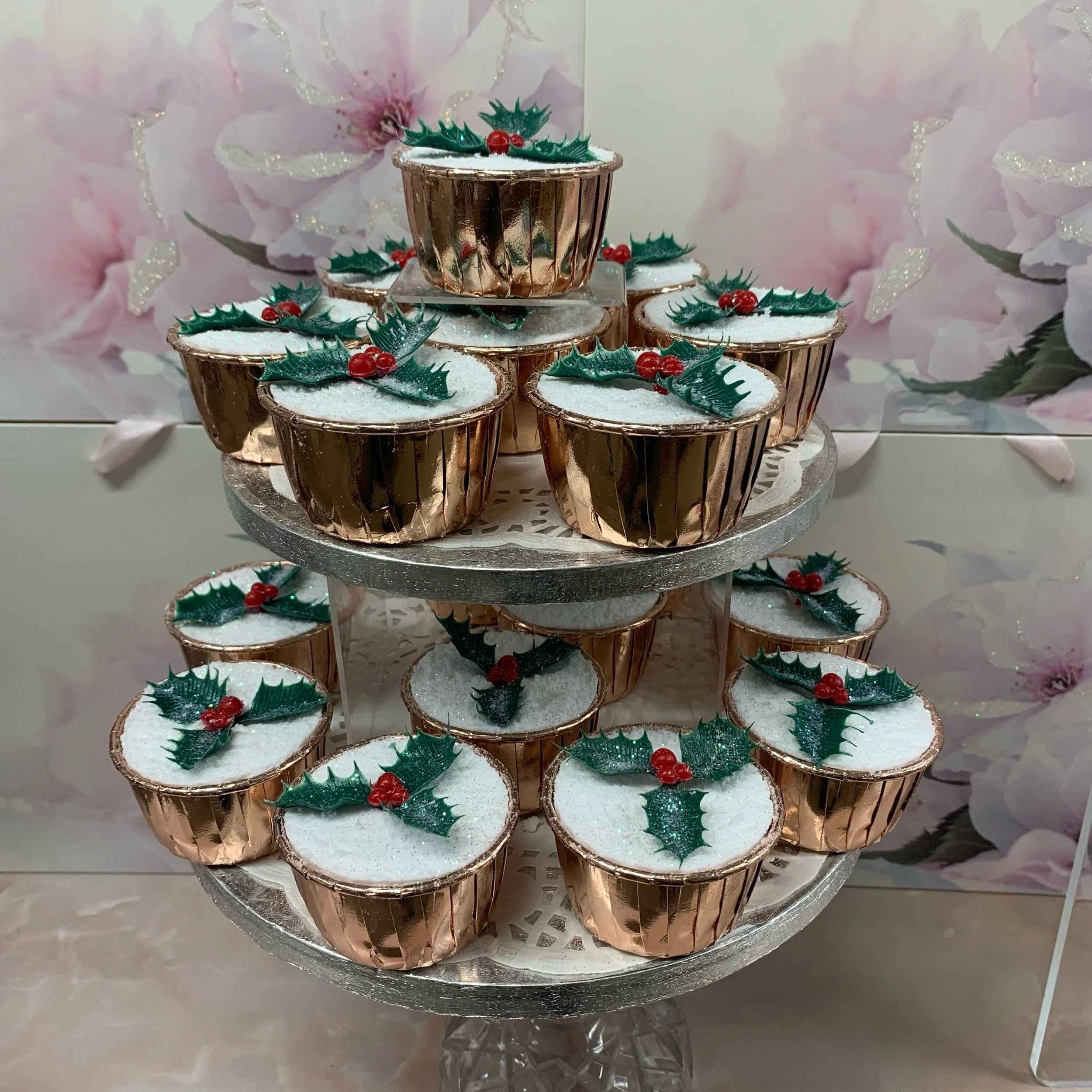 white bath bomb in rose gold foil muffin case with holly sprig decoration and orange flower fragrance