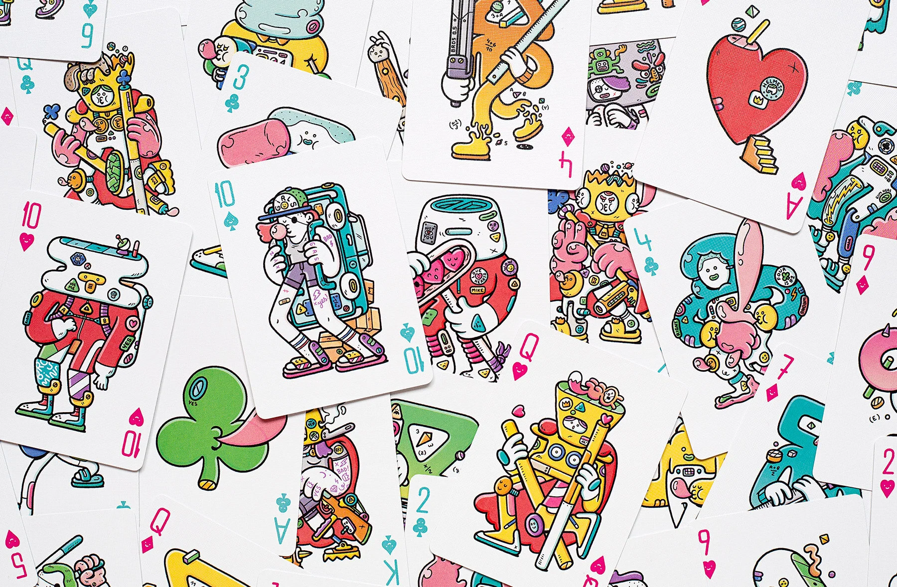 Top-down photo of colorful custom playing cards designed by Brosmind for Bicycle, filled with detailed original characters.