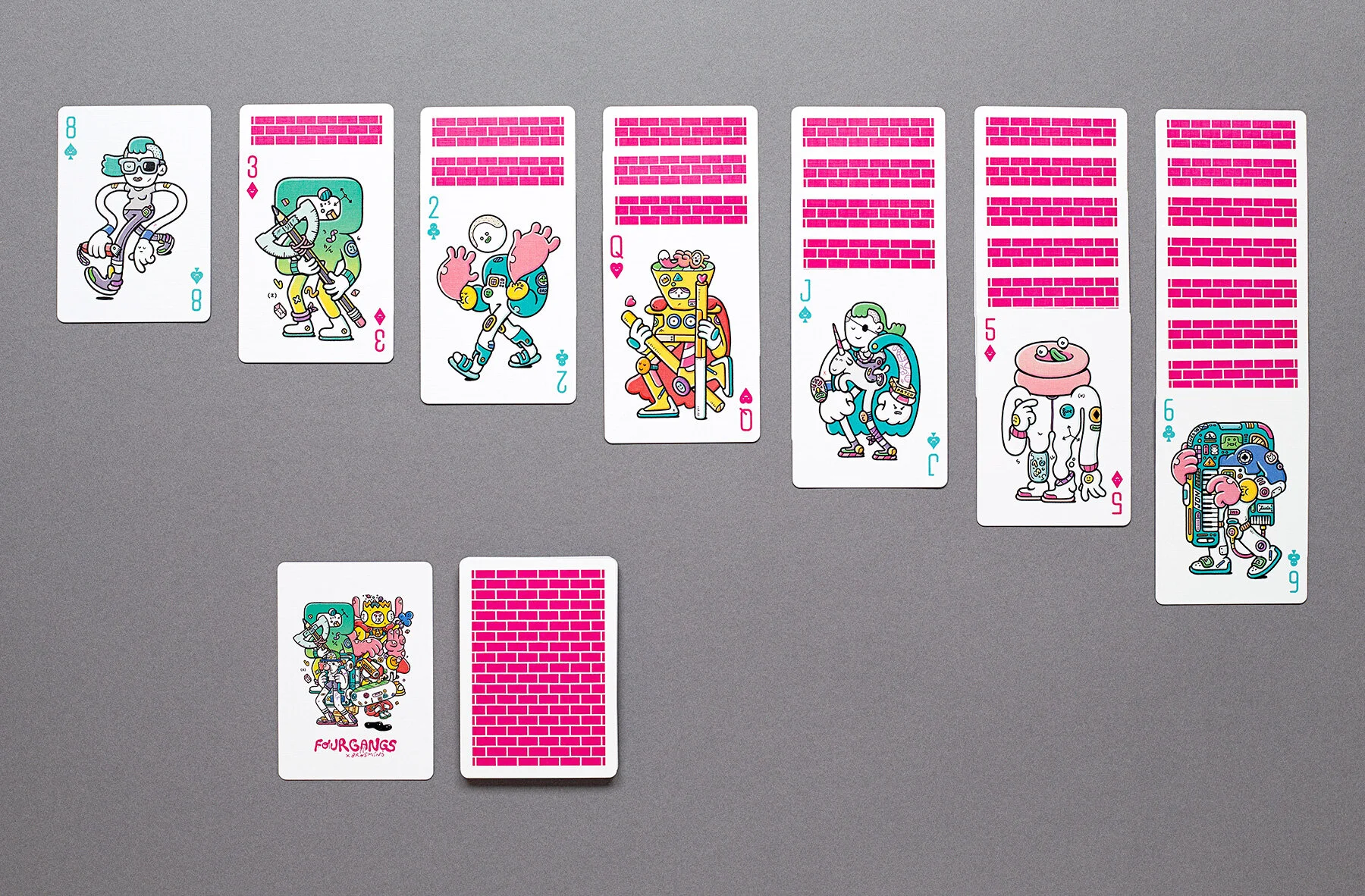 Top-down photograph of playing cards arranged in rows, showing intricate custom character designs by illustrators Brosmind.
