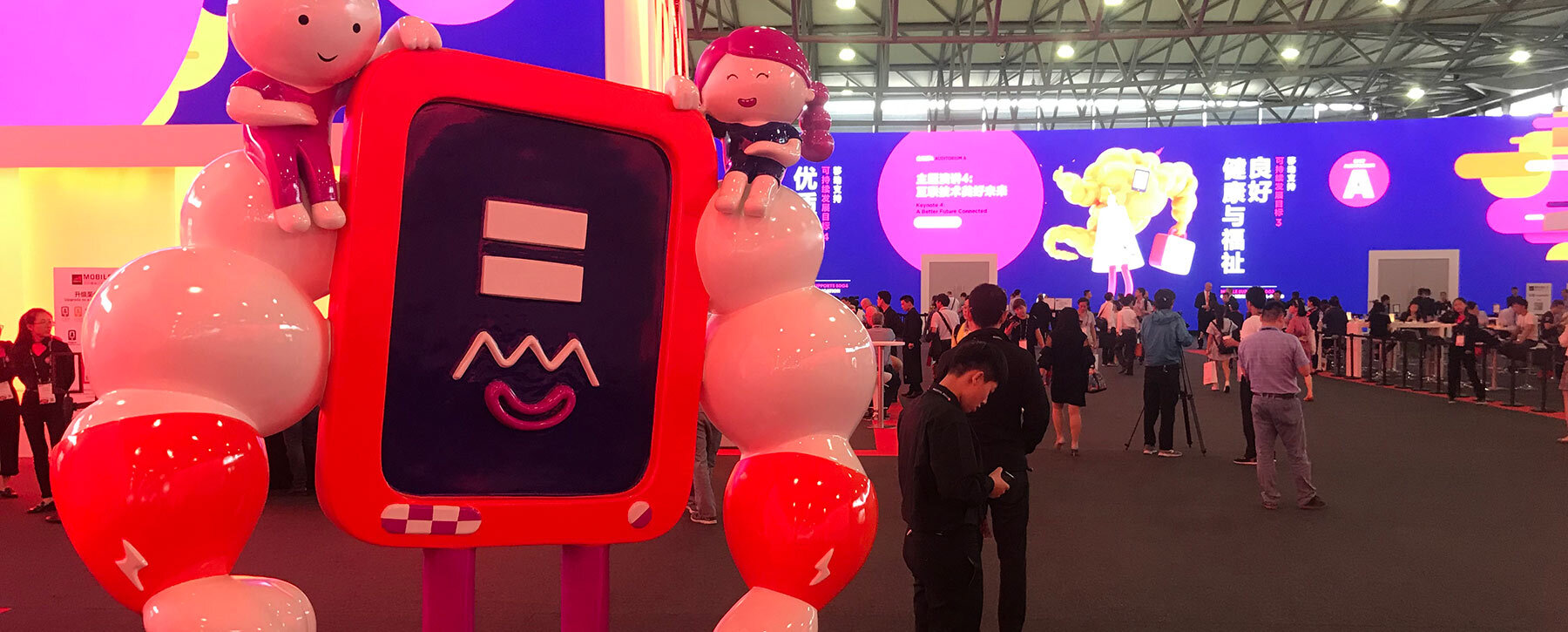Human-sized physical sculpture of the muscular tablet SDG character at MWC event venue.