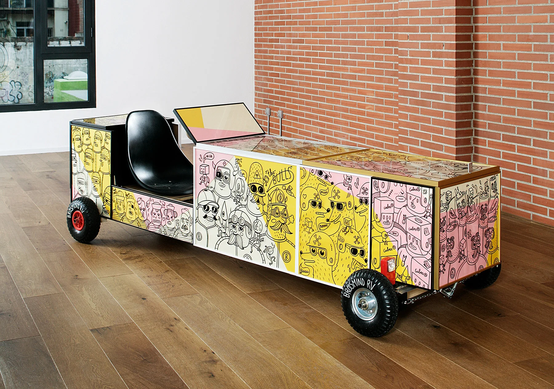 Handmade Brosmind RV go-kart with picture frame body panel illustrations in a loft with brick walls.