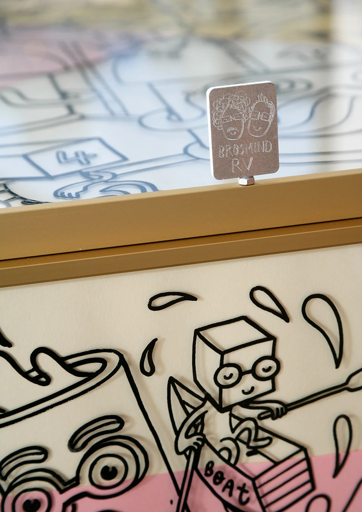 Detail shot of the metallic hood badge on the Brosmind RV featuring drawn portraits of the Mingarro brothers.