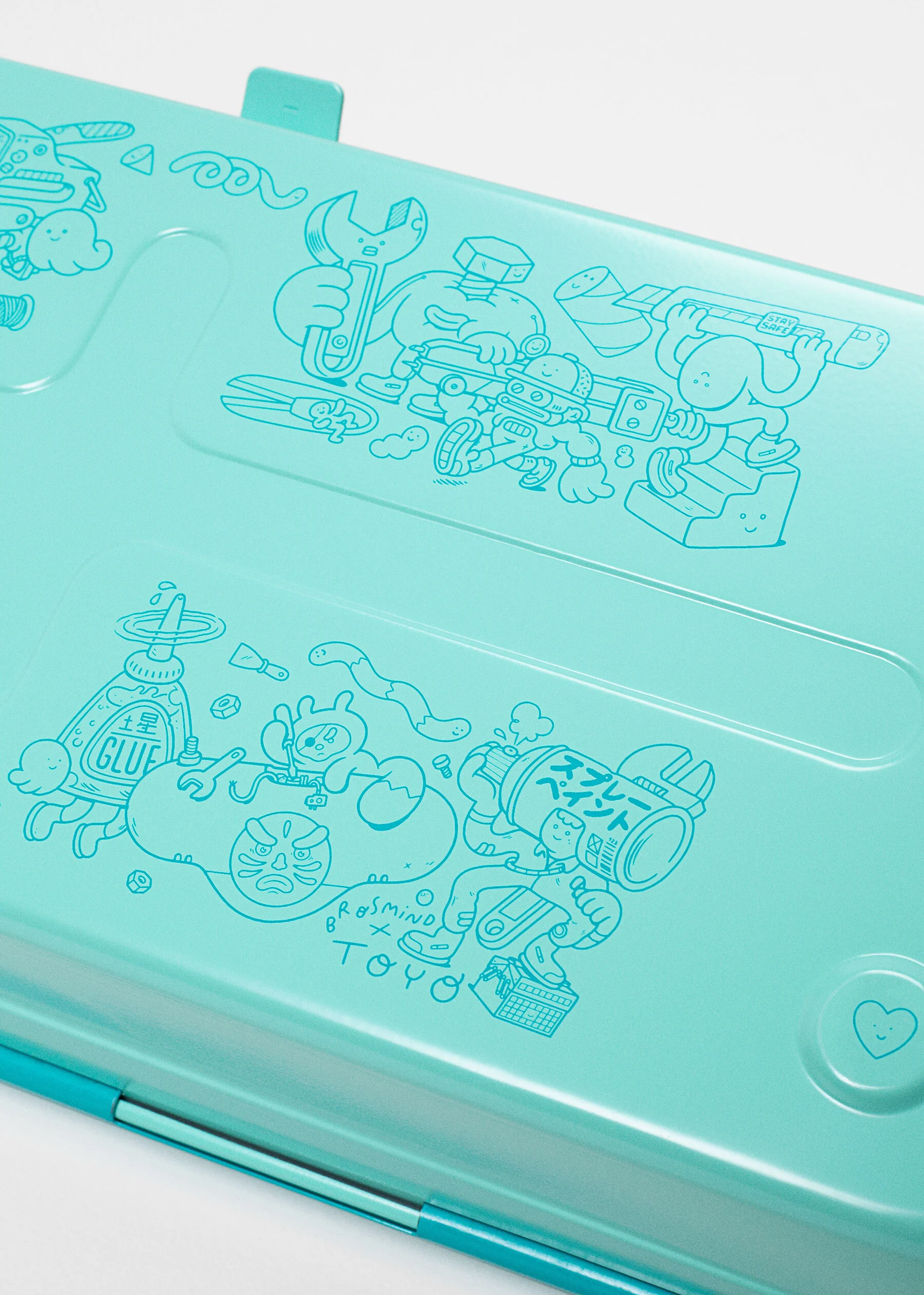 Detail photo of playful turquoise screenprinted Brosmind tool characters on the bottom of the TOYO box.