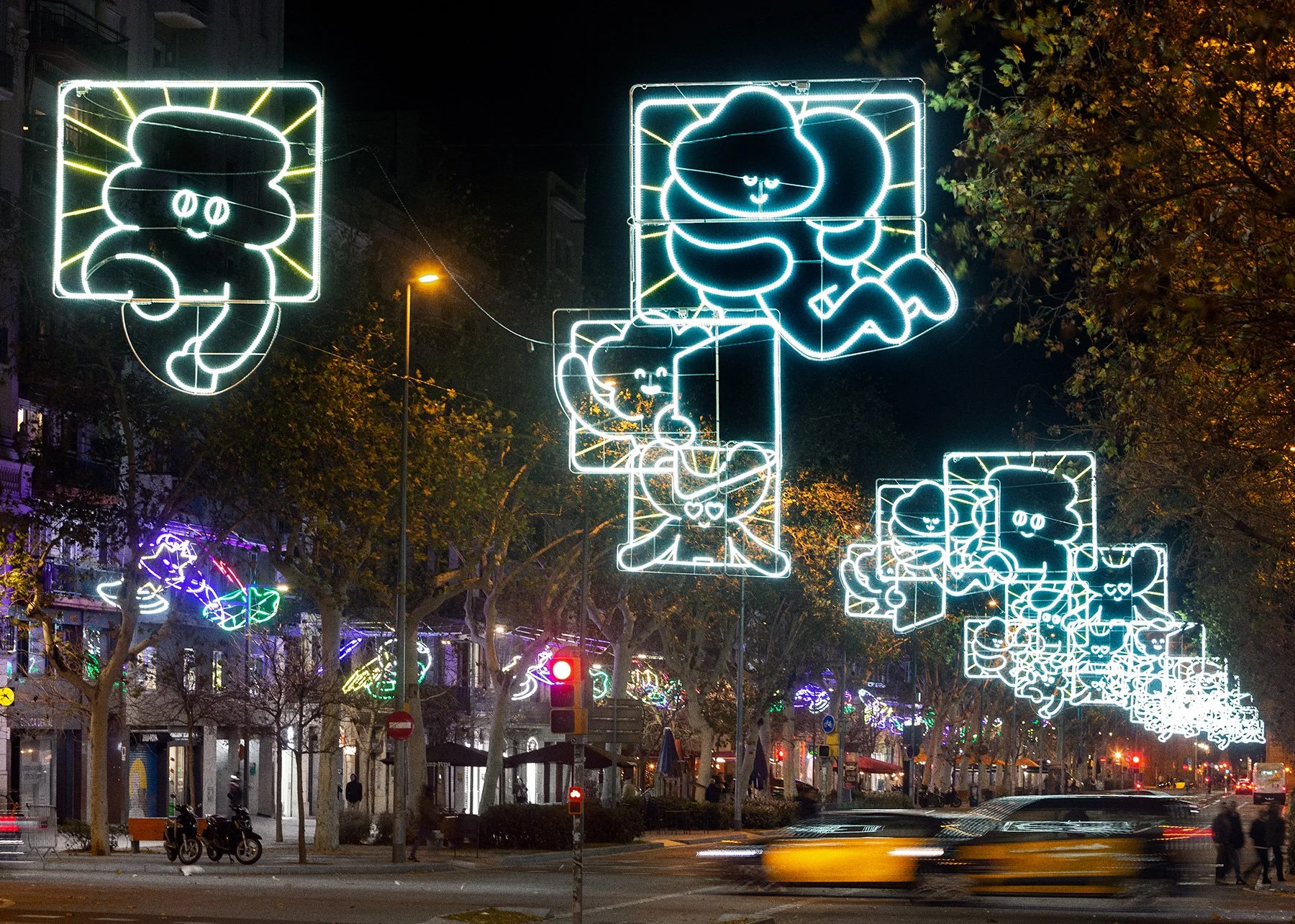 Night view of Passeig de Sant Joan decorated with repeating Kawaii comic panel Christmas lights by Brosmind.