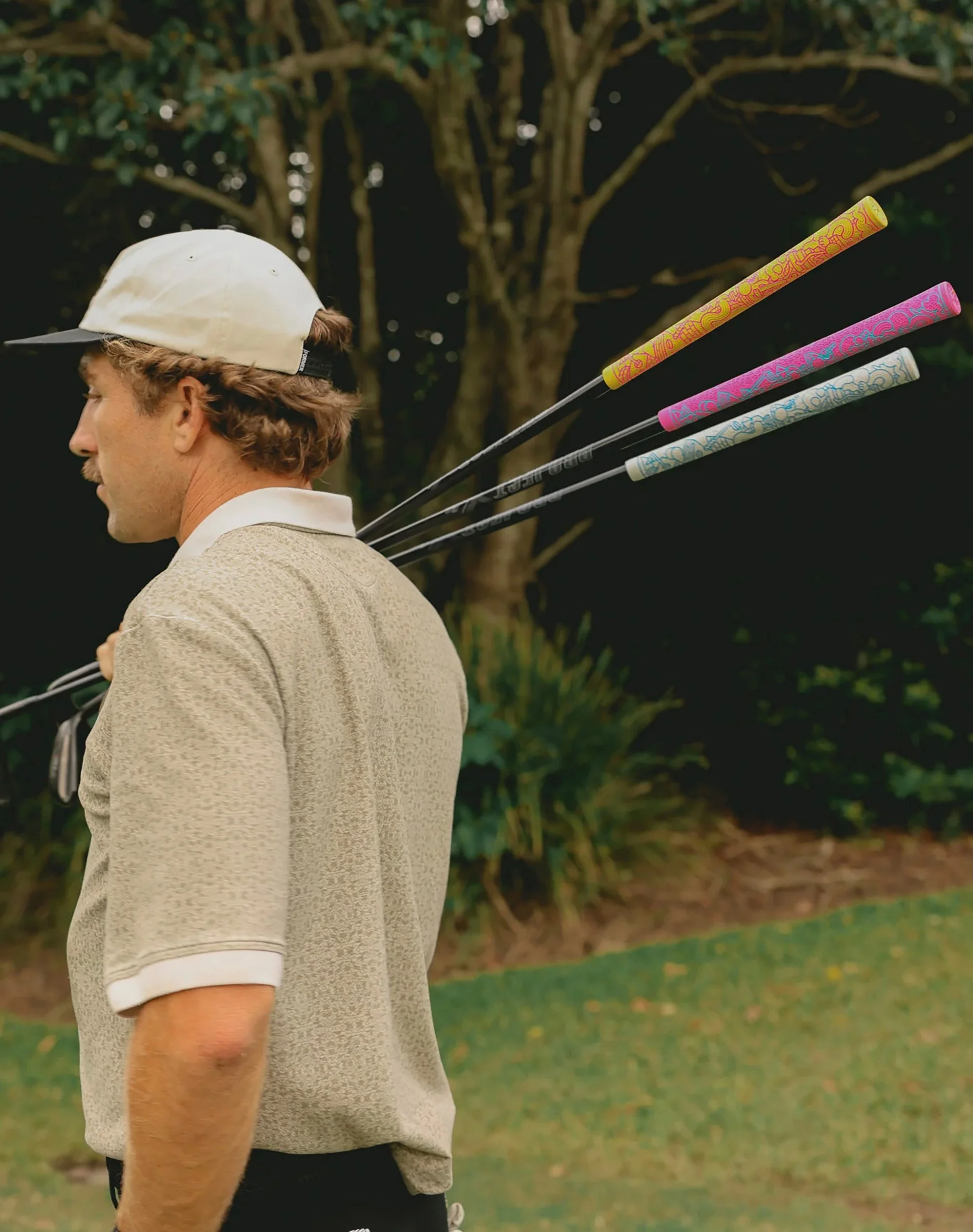 Side profile view of a golfer on the green holding a golf club with custom graphic grips designed by Brosmind for RIPIT Grips.