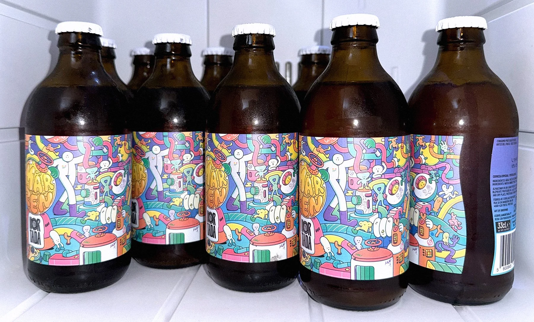 Product photograph of a refrigerator filled with Nortada Märzen craft beer bottles featuring Brosmind's vibrant custom label illustration design.