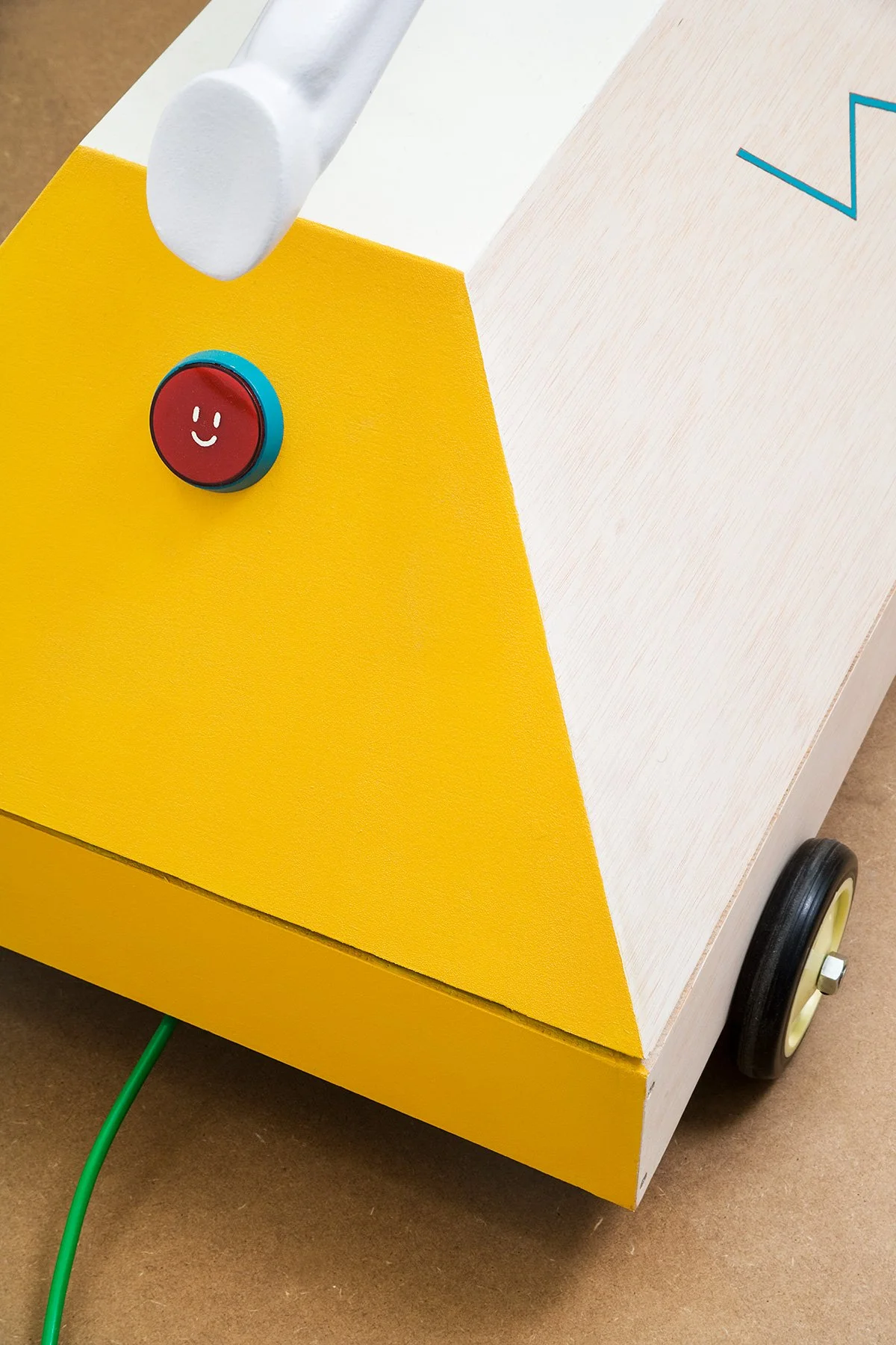 Close-up photo of the red smiley face power button on the base of Brosmind's mechanical unicorn ride.