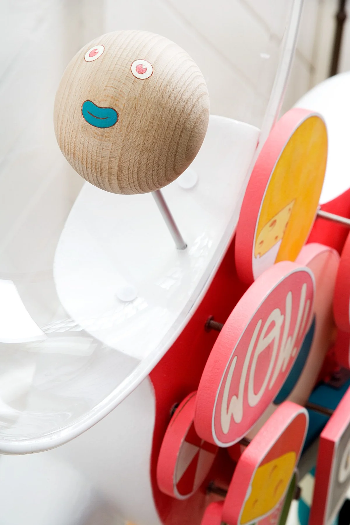  Close-up of a hand-painted wooden sphere with eyes and mouth on the mechanical unicorn sculpture.