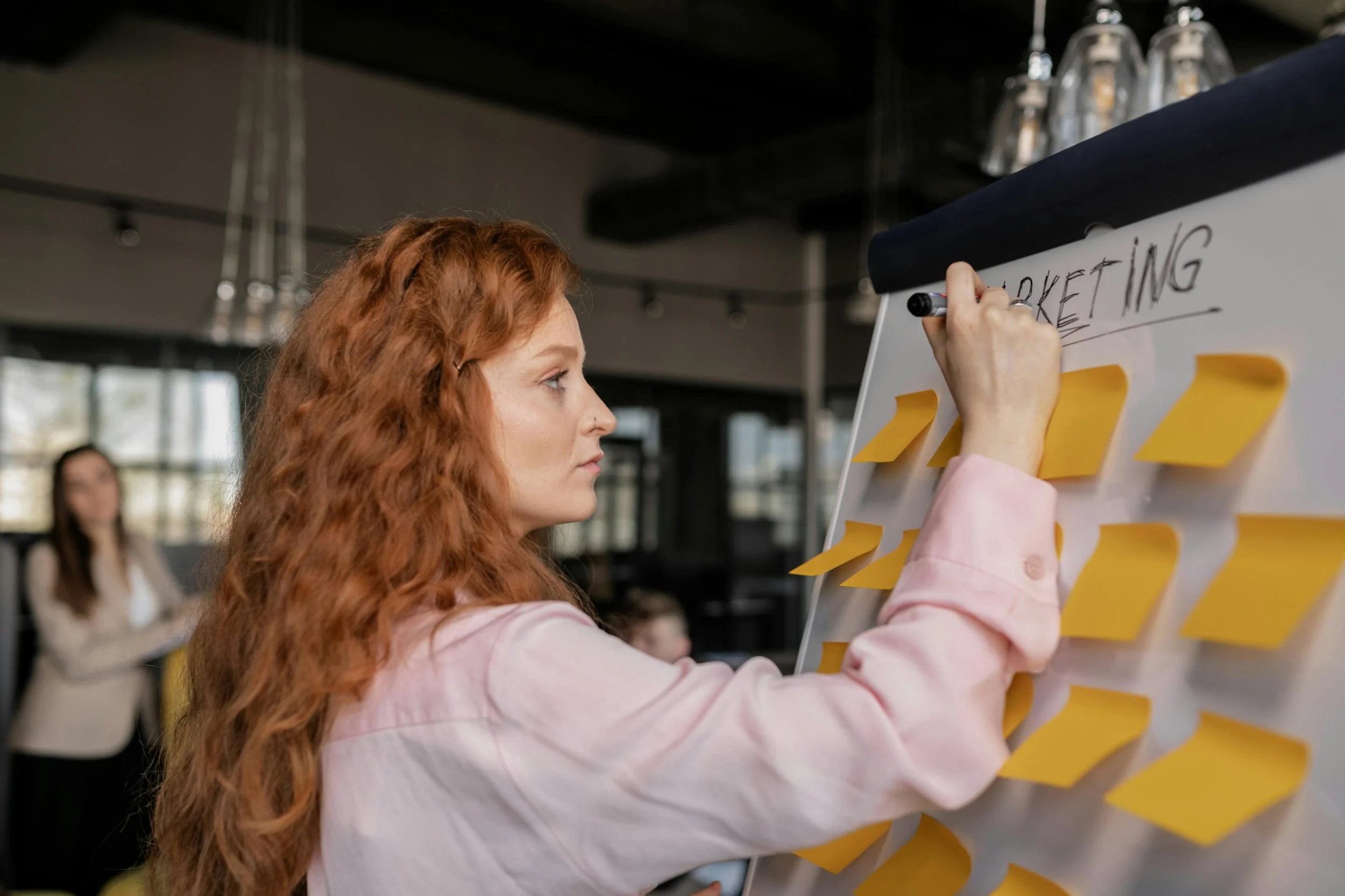 Small business owner mapping out low-cost marketing strategies on a whiteboard