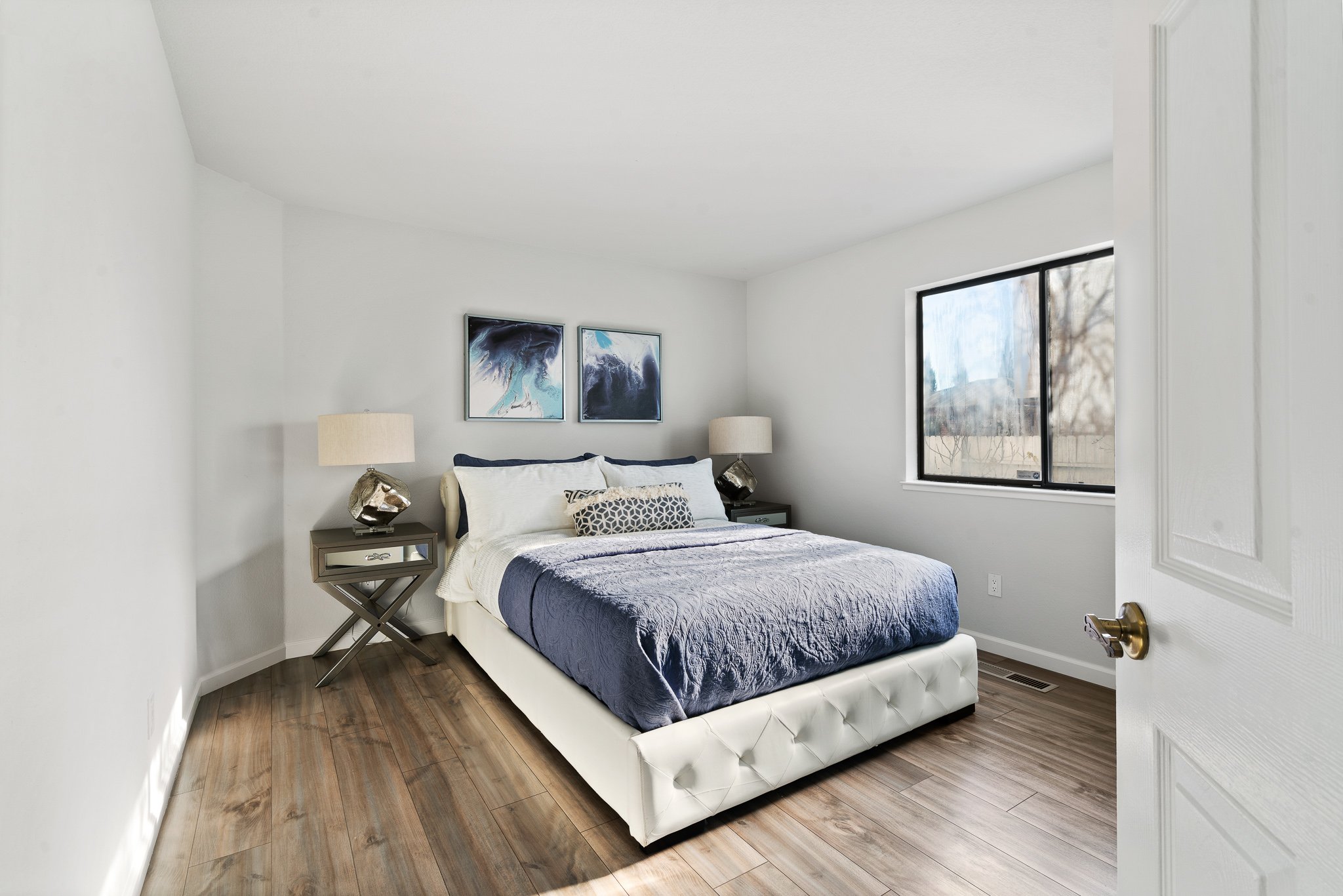 Added wood floors to this bedroom with bed, night stands and artwork to complete this bedroom staging.