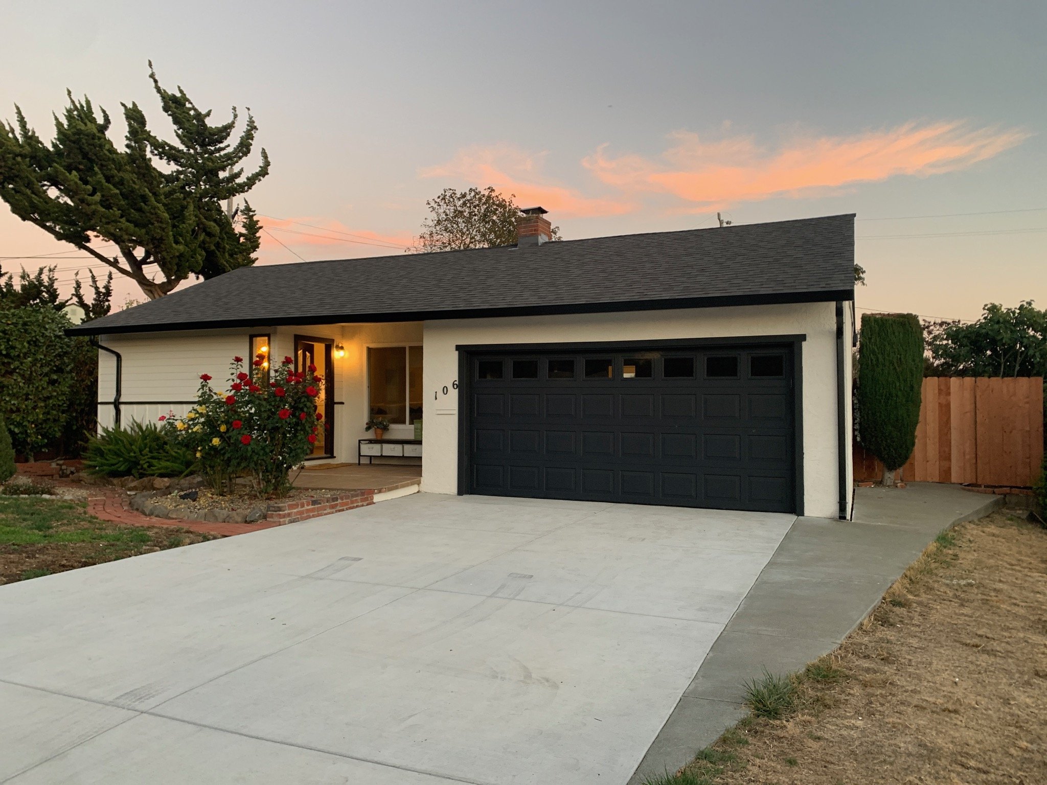Cleaned up exterior of ranch style home. Modern finishes. new Black garage door, new black gutters and trim, cream color exterior paint