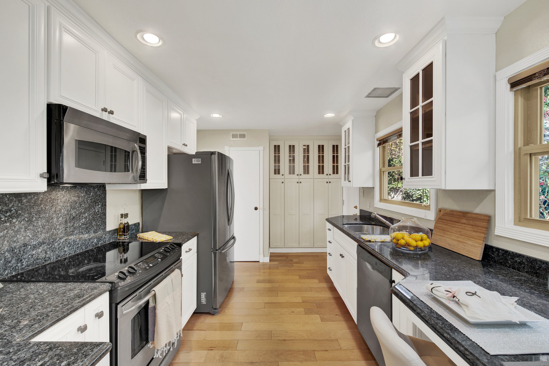 Wood cabinets painted white in galley style kitchen for a staged home to sell.