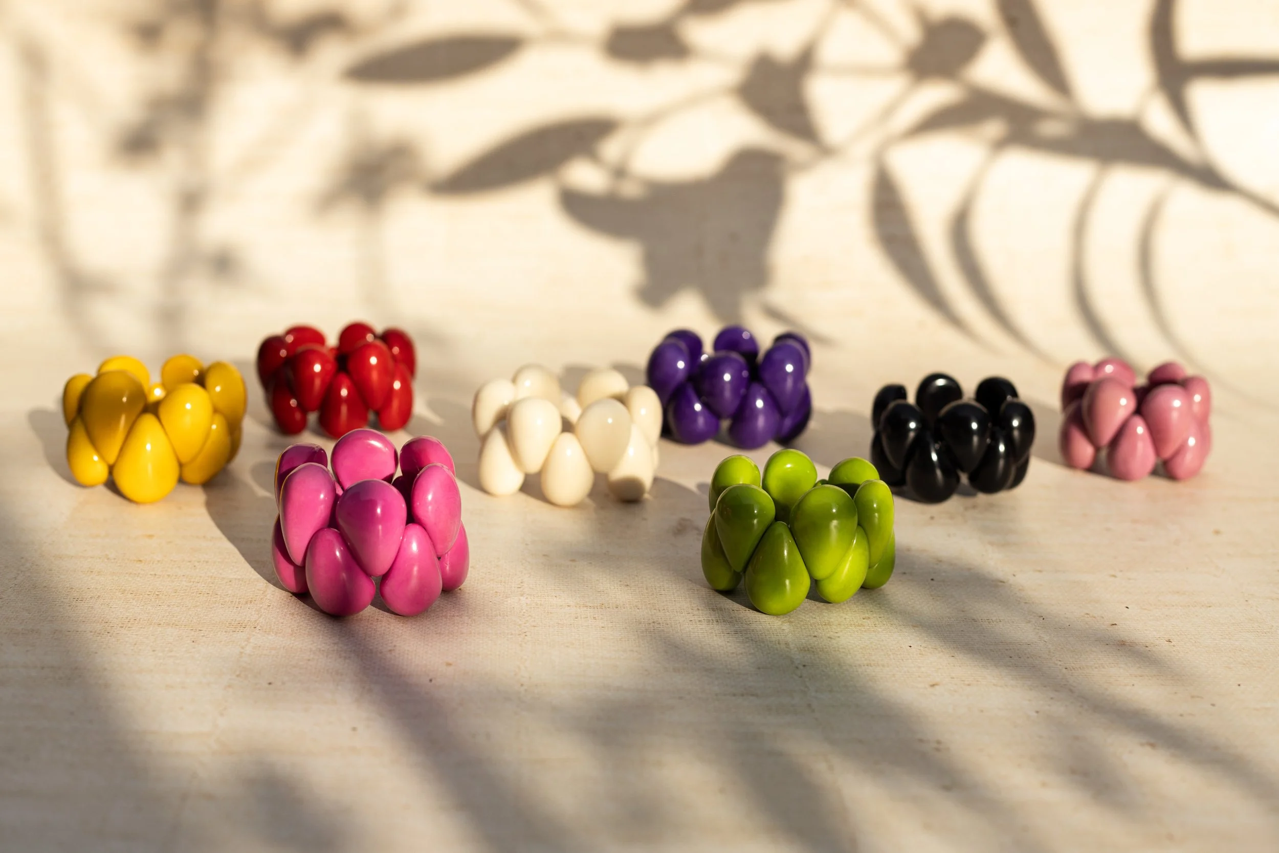 Lifestyle product photo showing bracelets next to each other under ed of the day sun light and shades of flowers