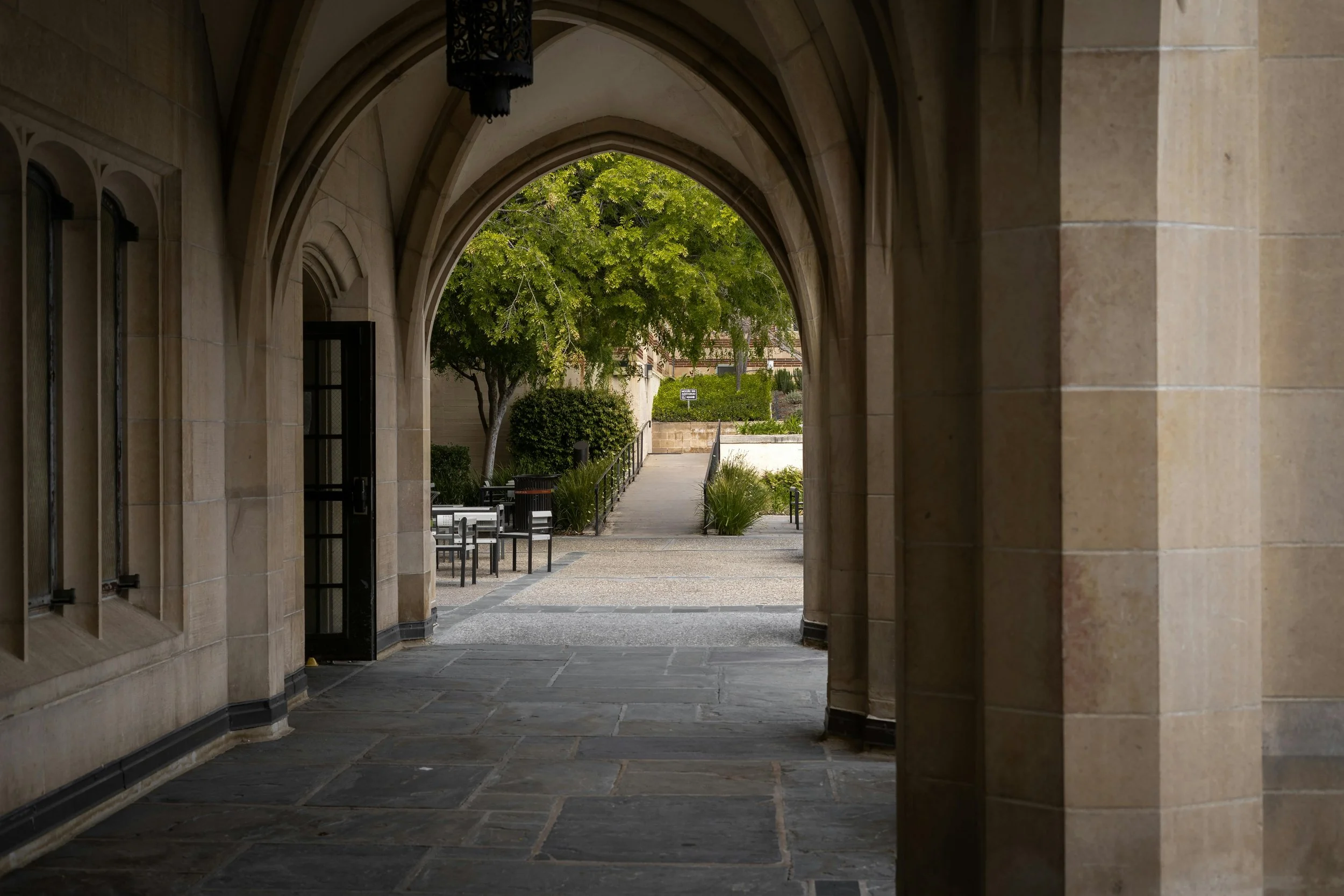 Stone archway on a college campus framing a walkway leading forward, symbolizing transition and academic course correction