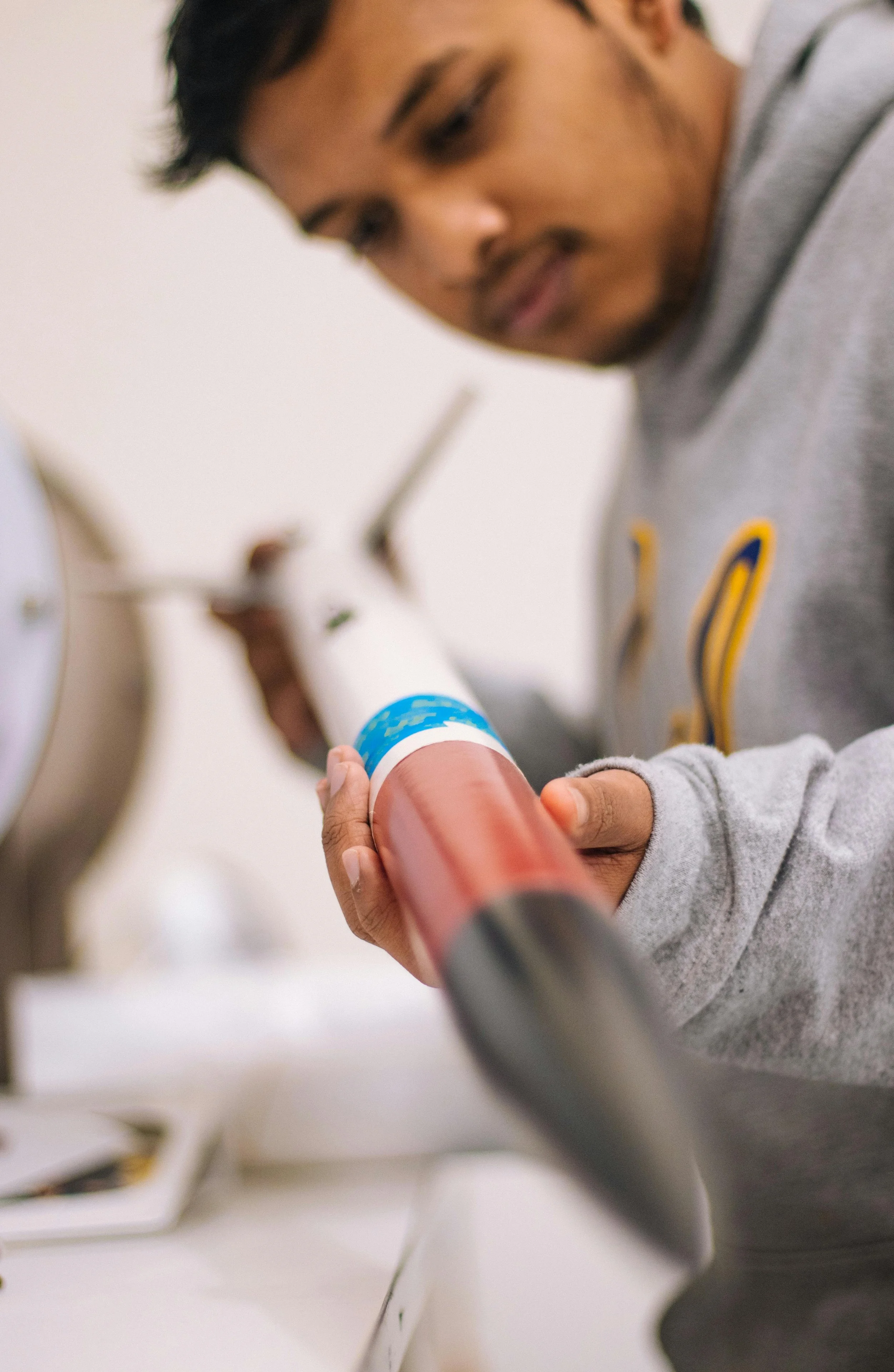Student examining an aerospace component during applied engineering coursework or laboratory work