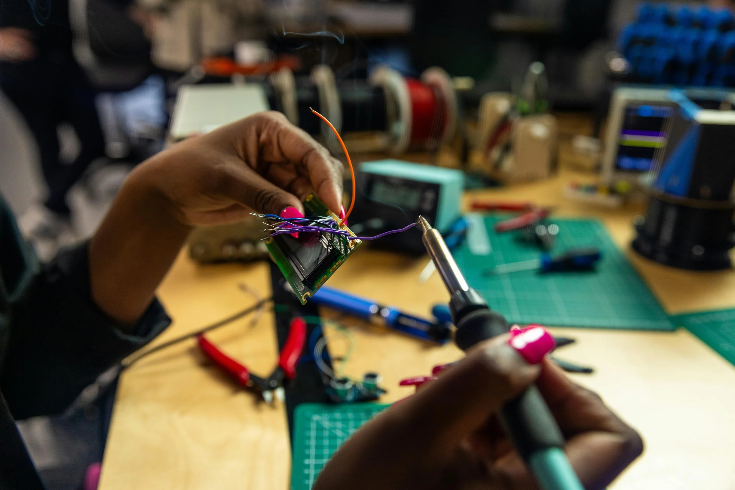 Engineering student soldering electronic components during a hands-on lab course