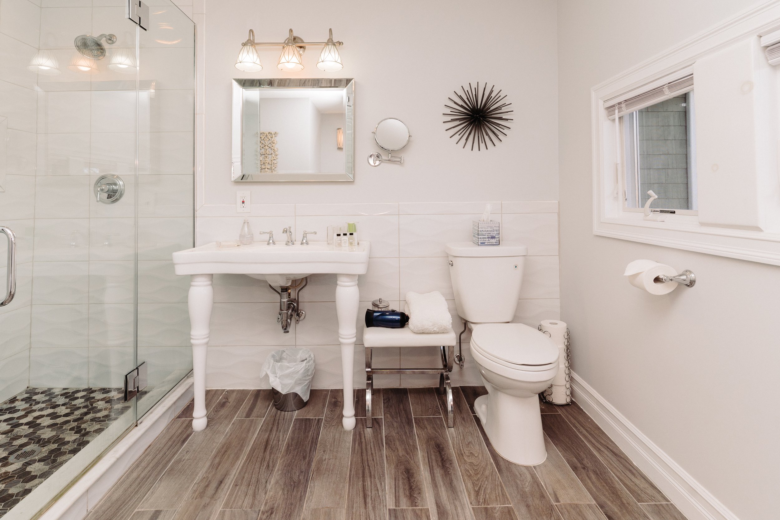 The Bathroom Of The East End Room With White Tile, Mid Century Décor and Standing Shower