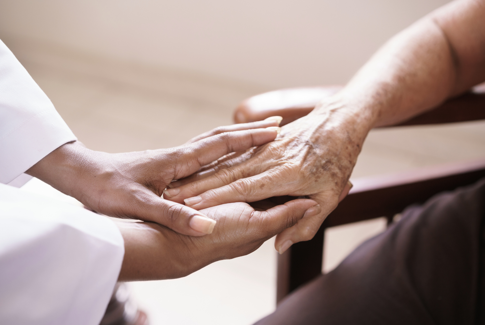 Physician holding hands of an old patient