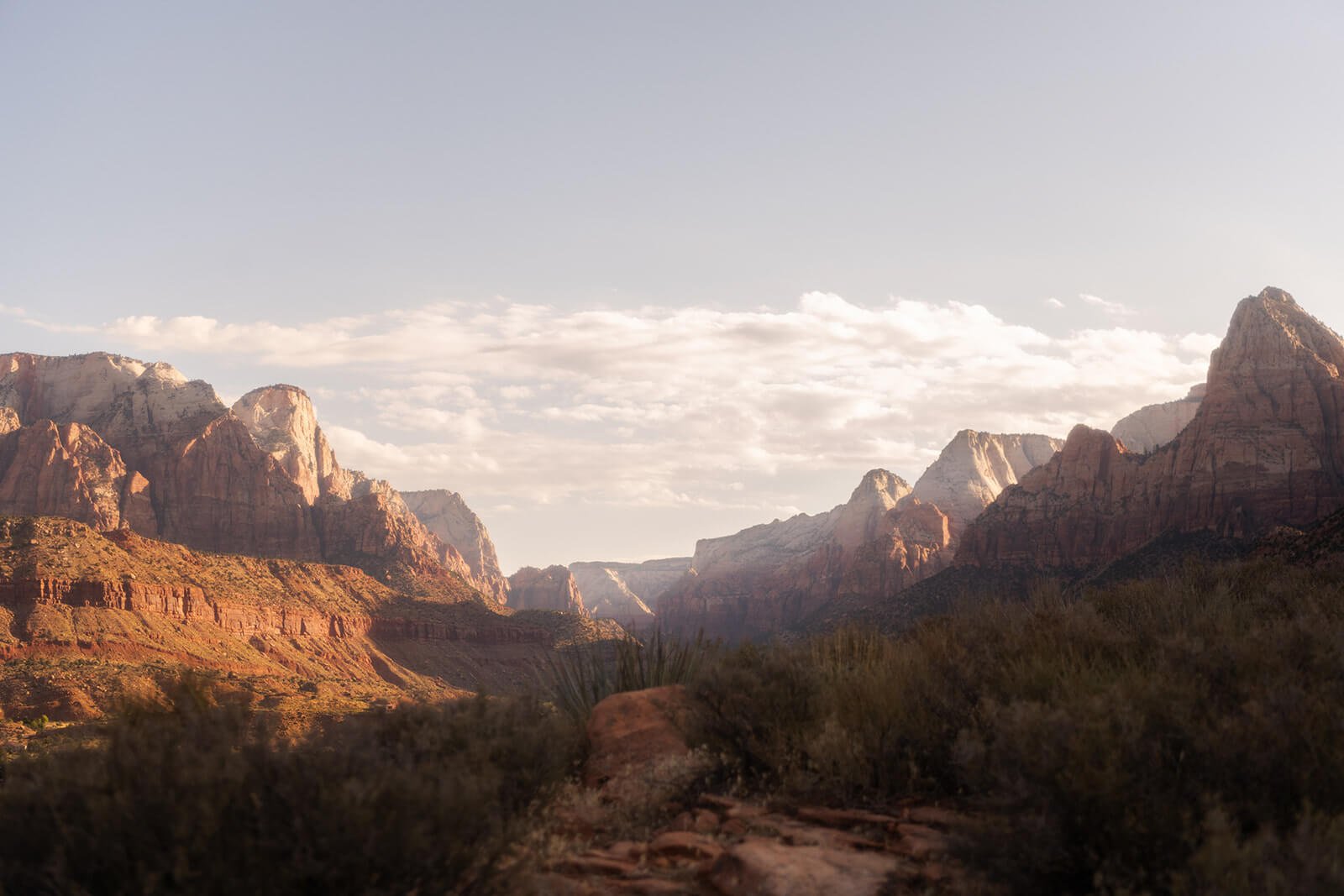Southwest United States mountains during sunset with red rock formations and sparse desert vegetation.