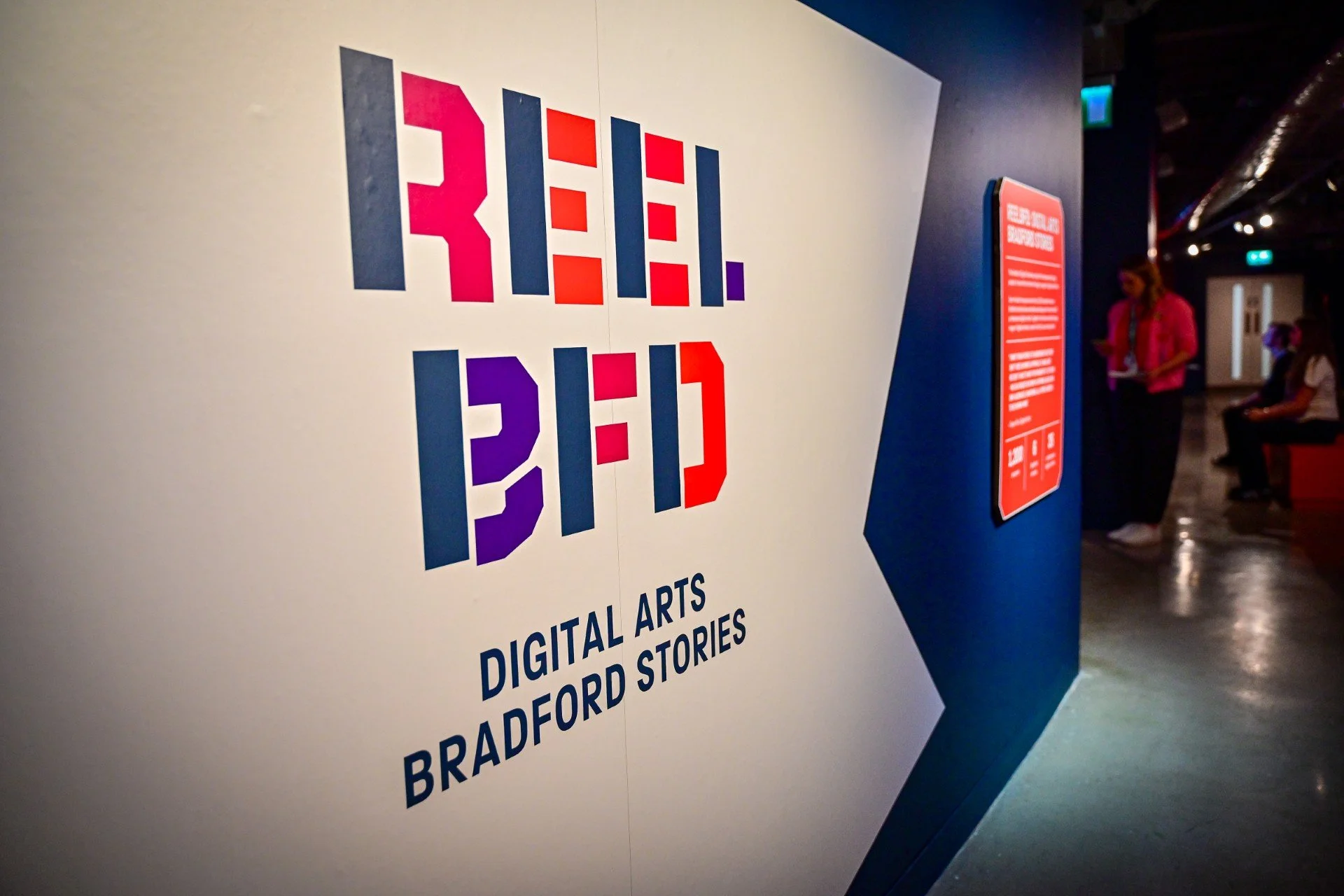 Exhibition title wall for ReelBFD: Digital Arts, Bradford Stories, featuring the bold logo in red and purple at the National Science and Media Museum.