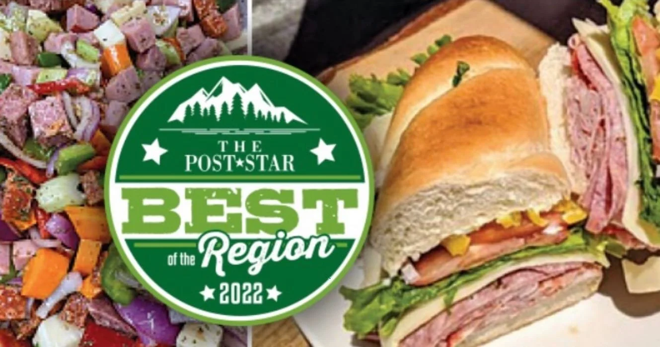 A platter of assorted salad vegetables and a sandwich with deli meats, greens, and vegetables. A green badge overlaps part of the platter, reading "The Post-Star Best of the Region 2022."